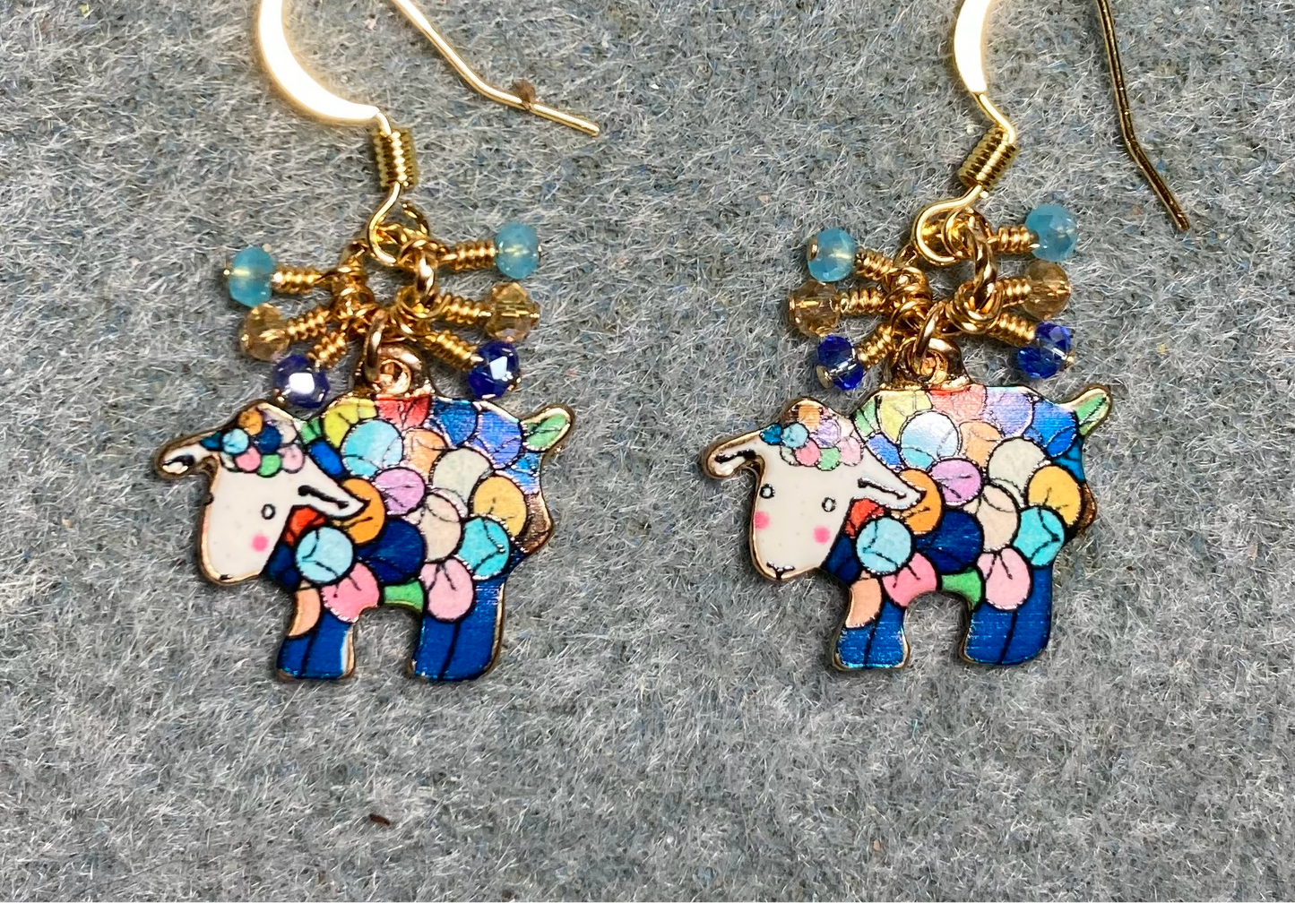 Colorful enamel sheep charm earrings adorned with tiny dangling turquoise, amber, and dark blue Chinese crystal beads.