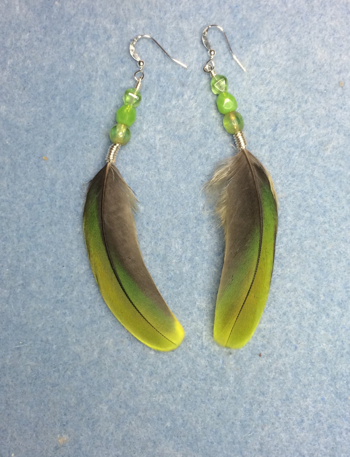 Lime green mini macaw feather earrings adorned with lime green Czech glass beads.