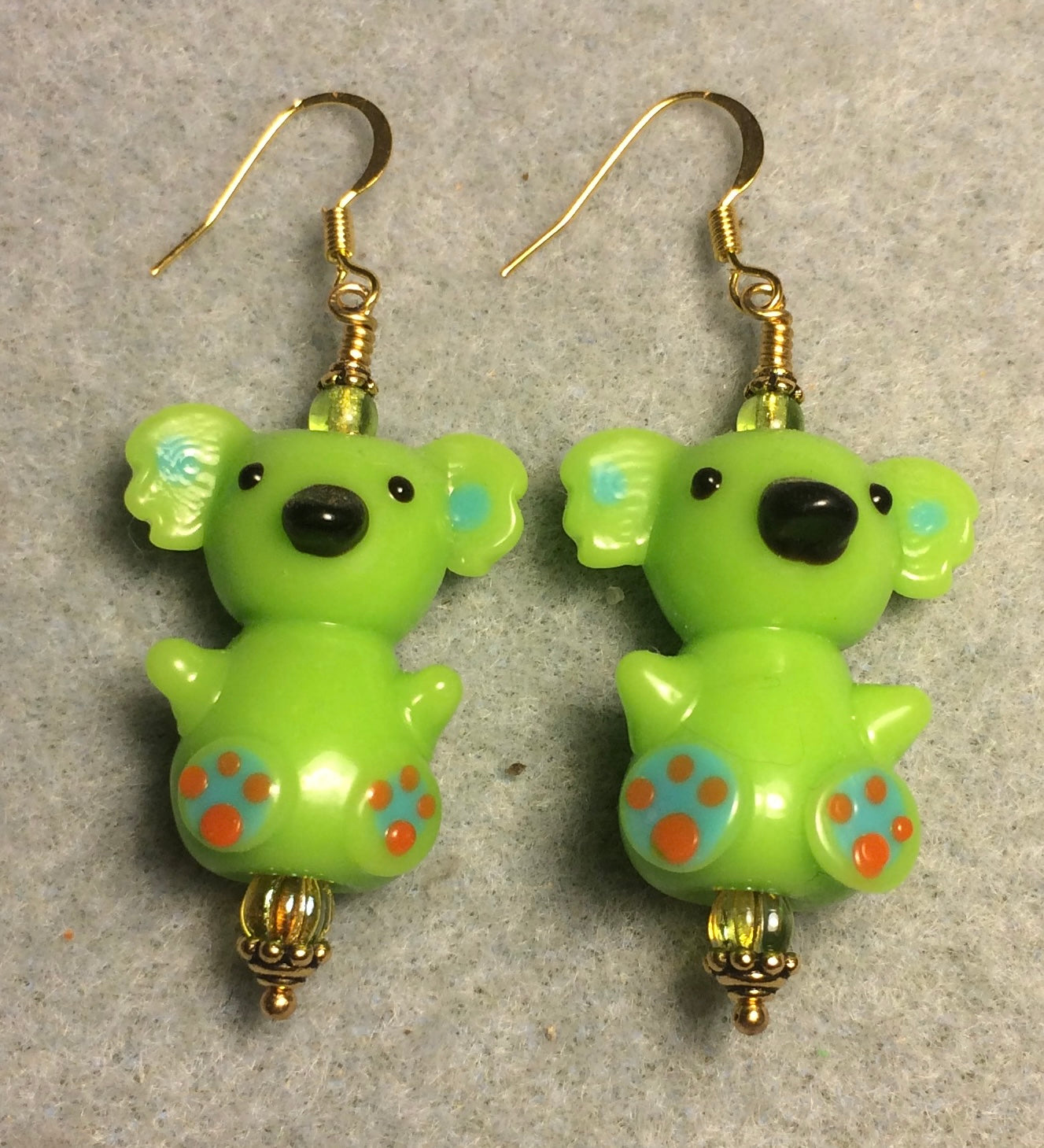 Large green lamp work koala bear bead earrings adorned with green Czech glass beads.