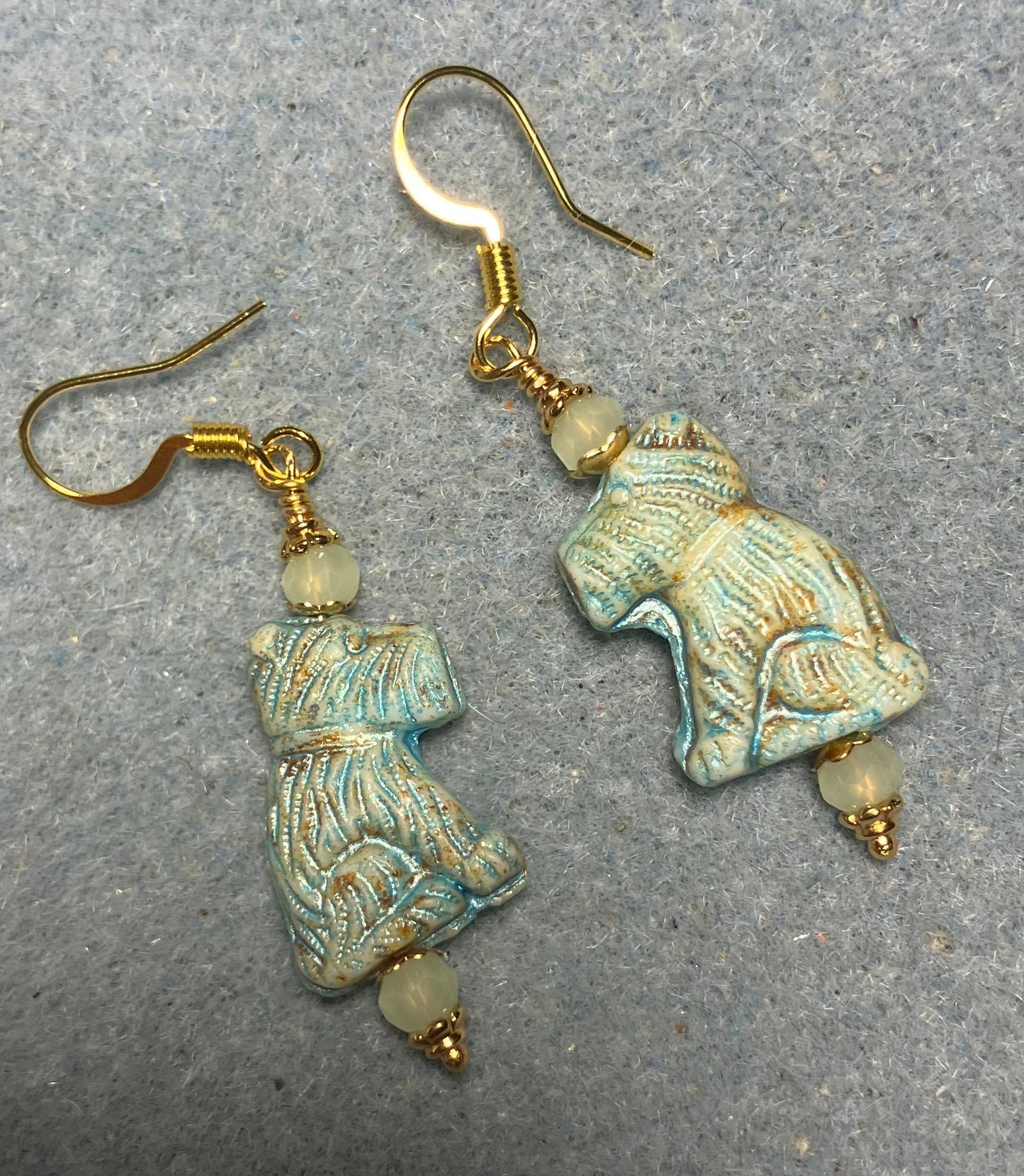 Light green Czech glass Schnauzer bead earrings adorned with light green Chinese crystal beads.