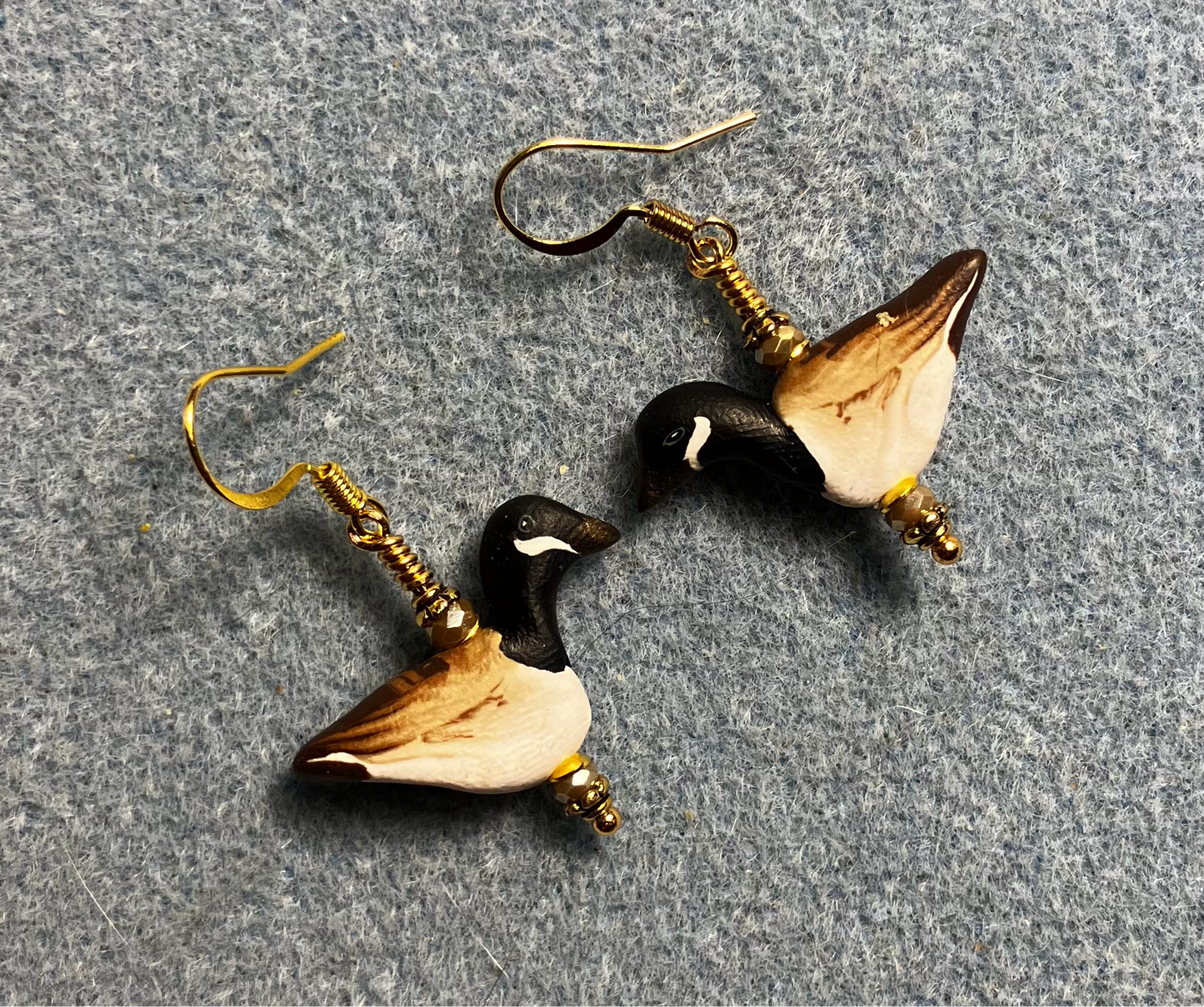 Black, brown, and tan polymer clay goose bead earrings adorned with tan Chinese crystal beads.