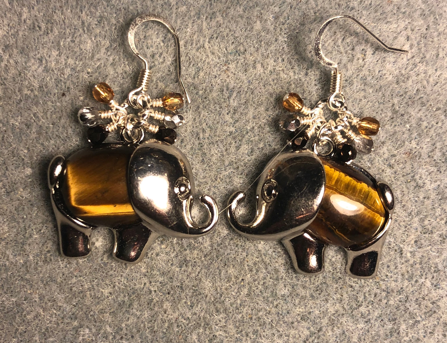 Large silver and brown tigereye gemstone elephant charm earrings adorned with small dangling brown, amber, and silver Czech glass beads.