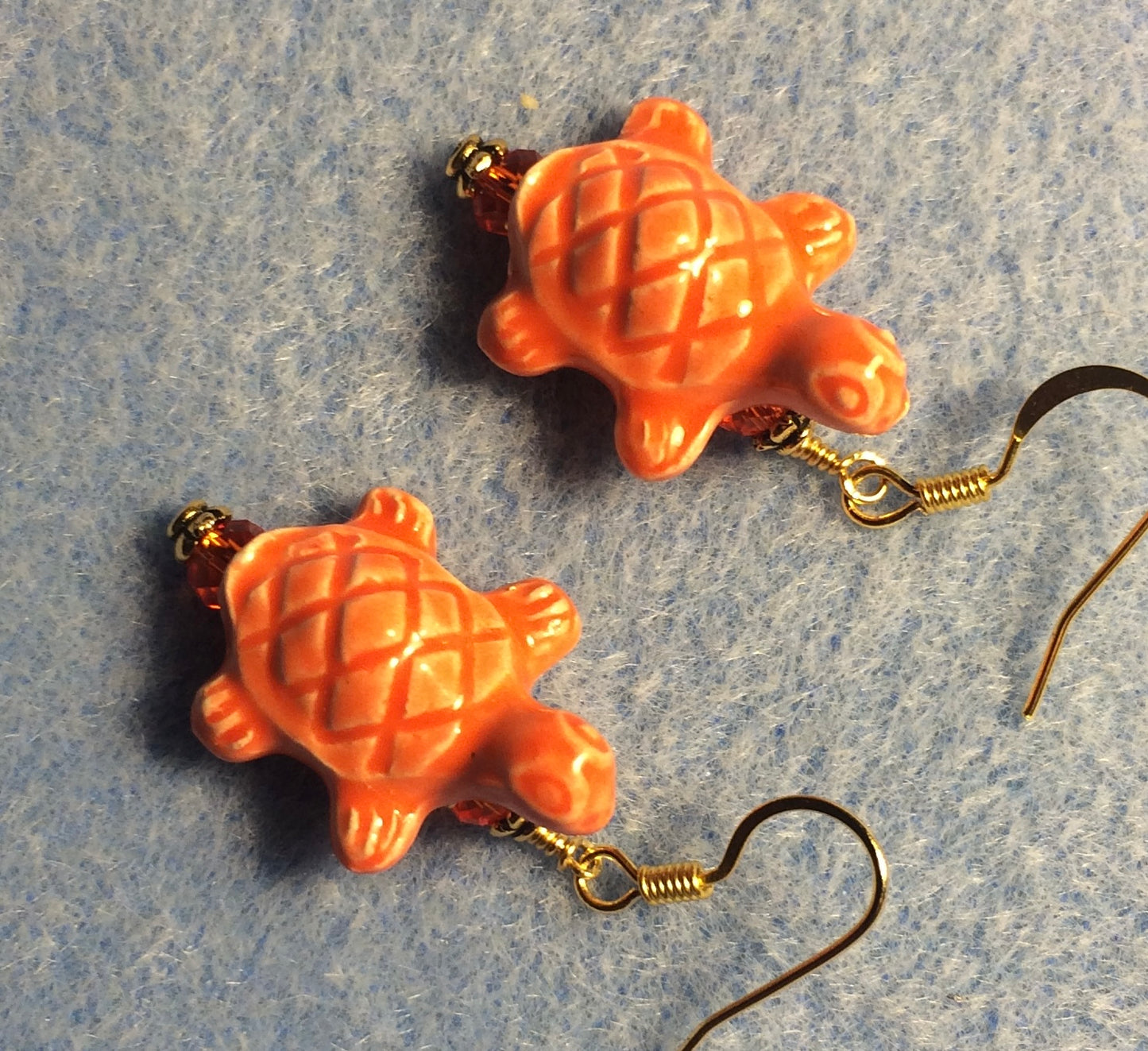 Orange ceramic turtle bead earrings adorned with orange Chinese crystal beads.