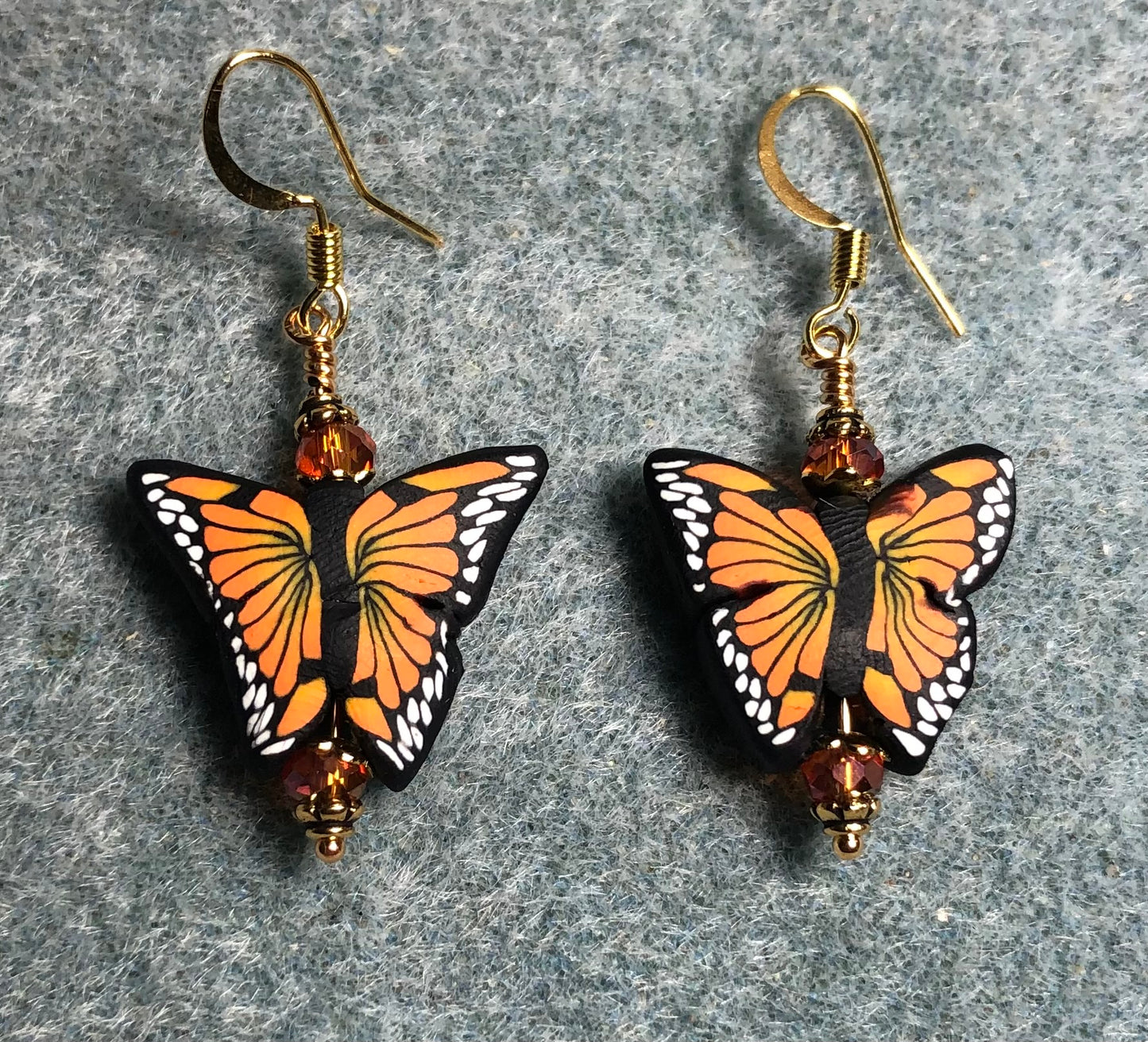 Orange and black polymer clay butterfly bead earrings adorned with orange Chinese crystal beads.