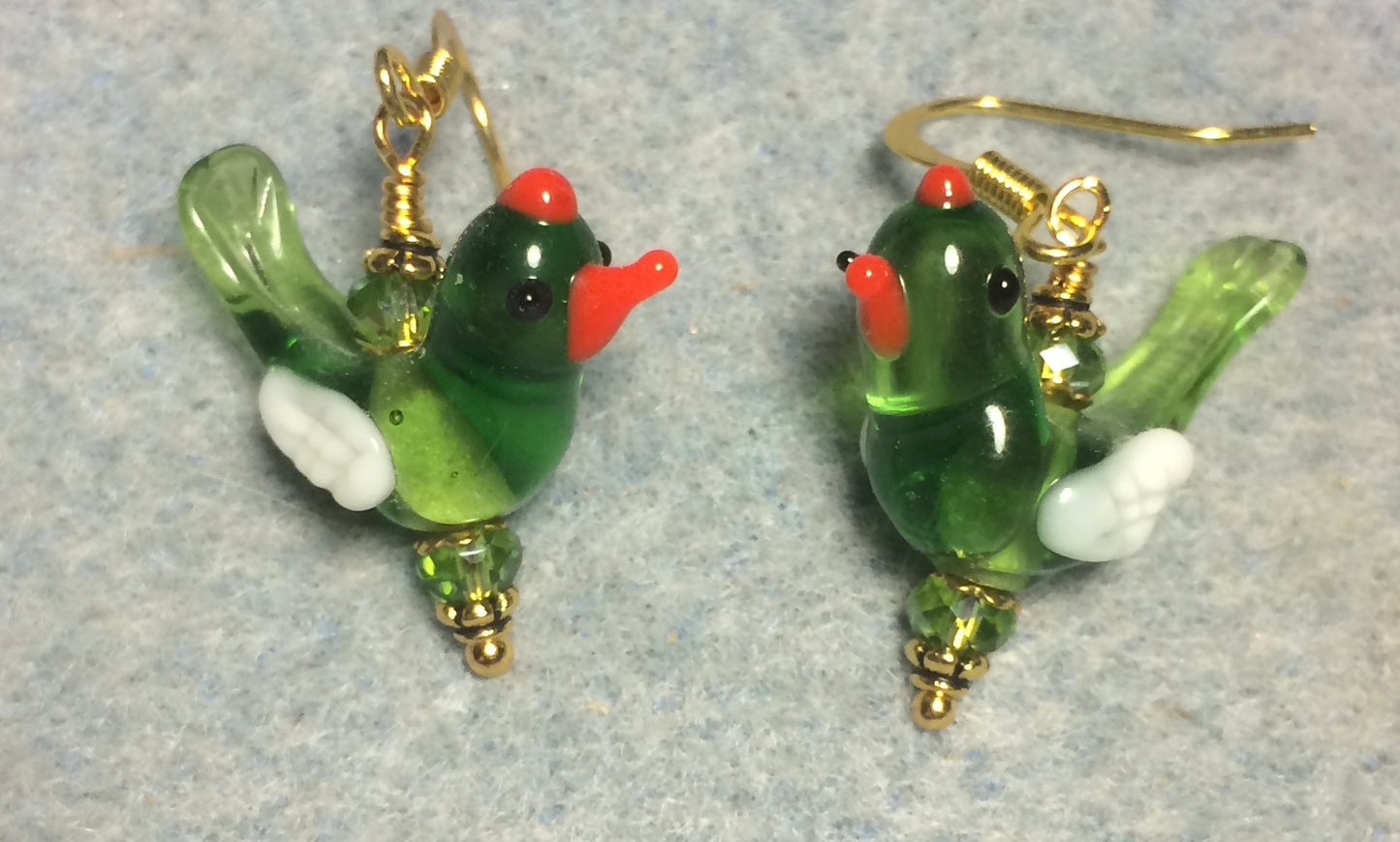 Translucent olive green and white lamp work songbird bead earrings adorned with olive green Chinese crystal beads.