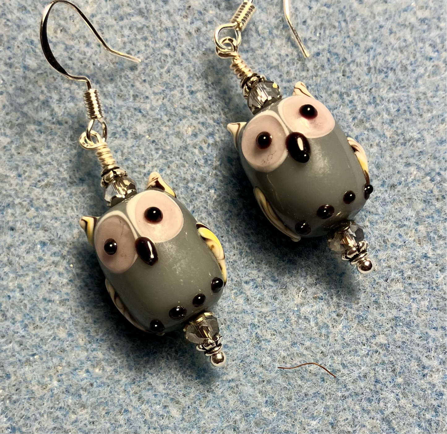 Gray lamp work owl bead earrings adorned with gray Chinese crystal beads.