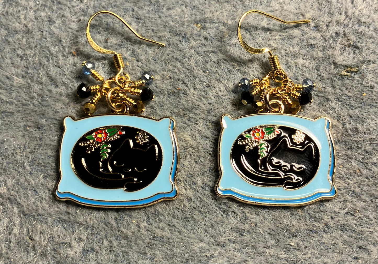 Black and blue enamel cat charm earrings adorned with tiny dangling black, blue, and gold Chinese crystal beads.