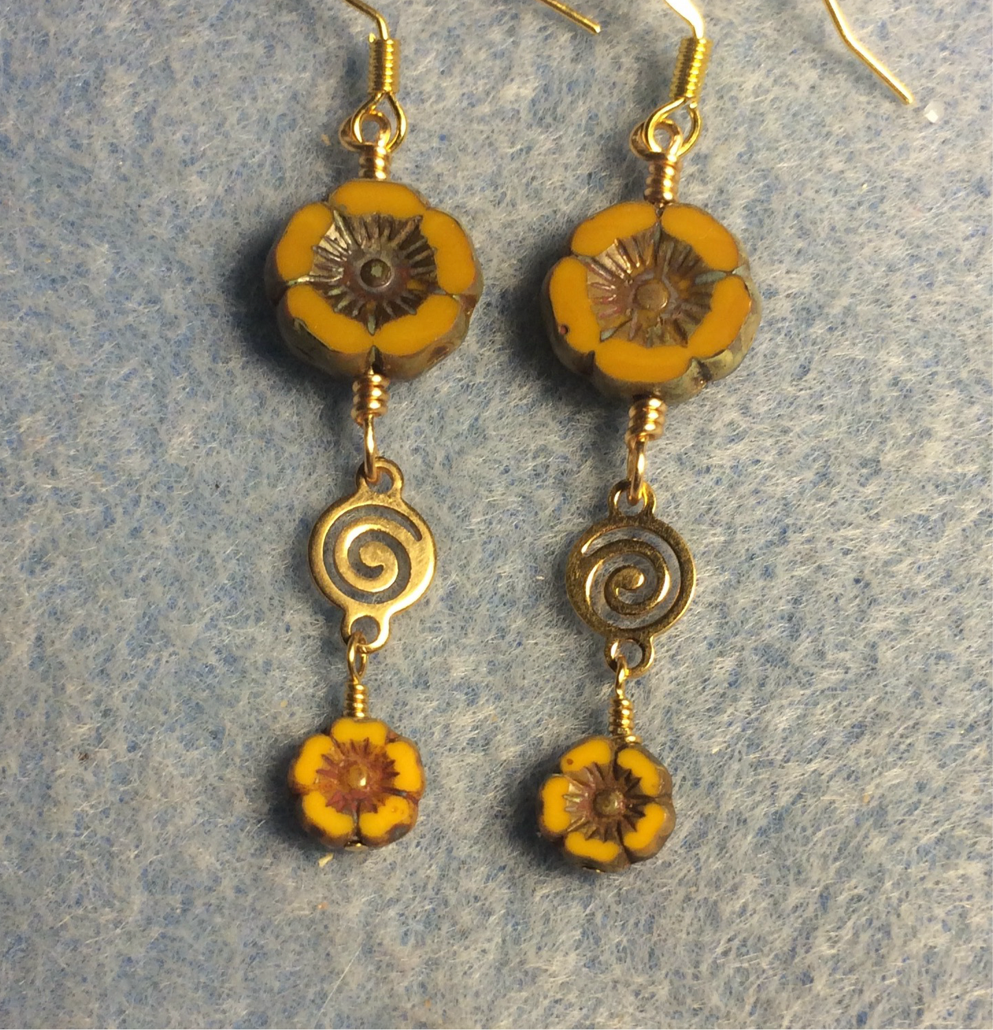 Opaque mustard yellow Czech glass pansy bead earrings adorned with gold swirly connectors and tiny opaque mustard yellow Czech glass pansy beads.