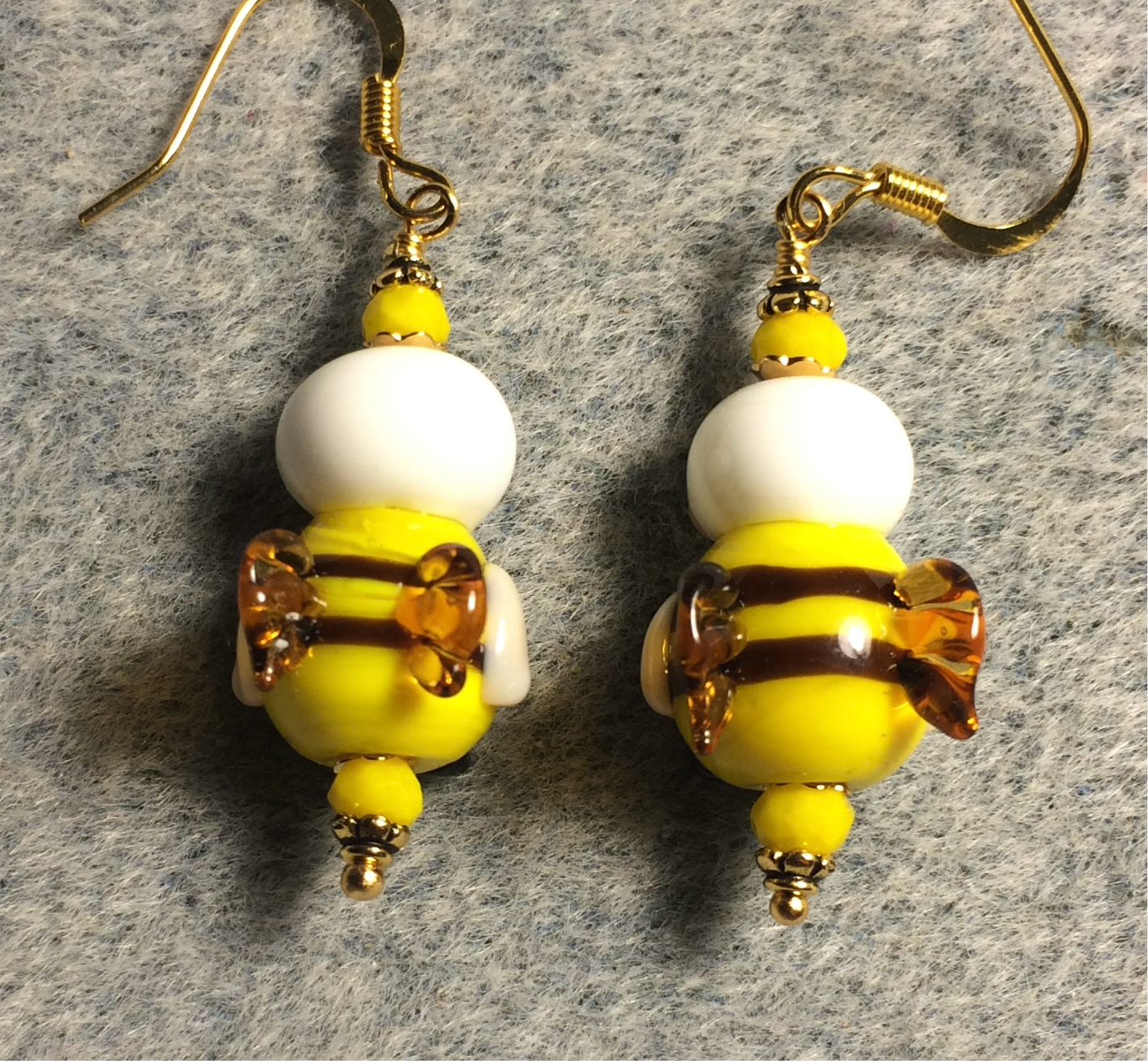 Black, yellow, and white lamp work striped honeybee bead earrings adorned with yellow Chinese crystal beads.