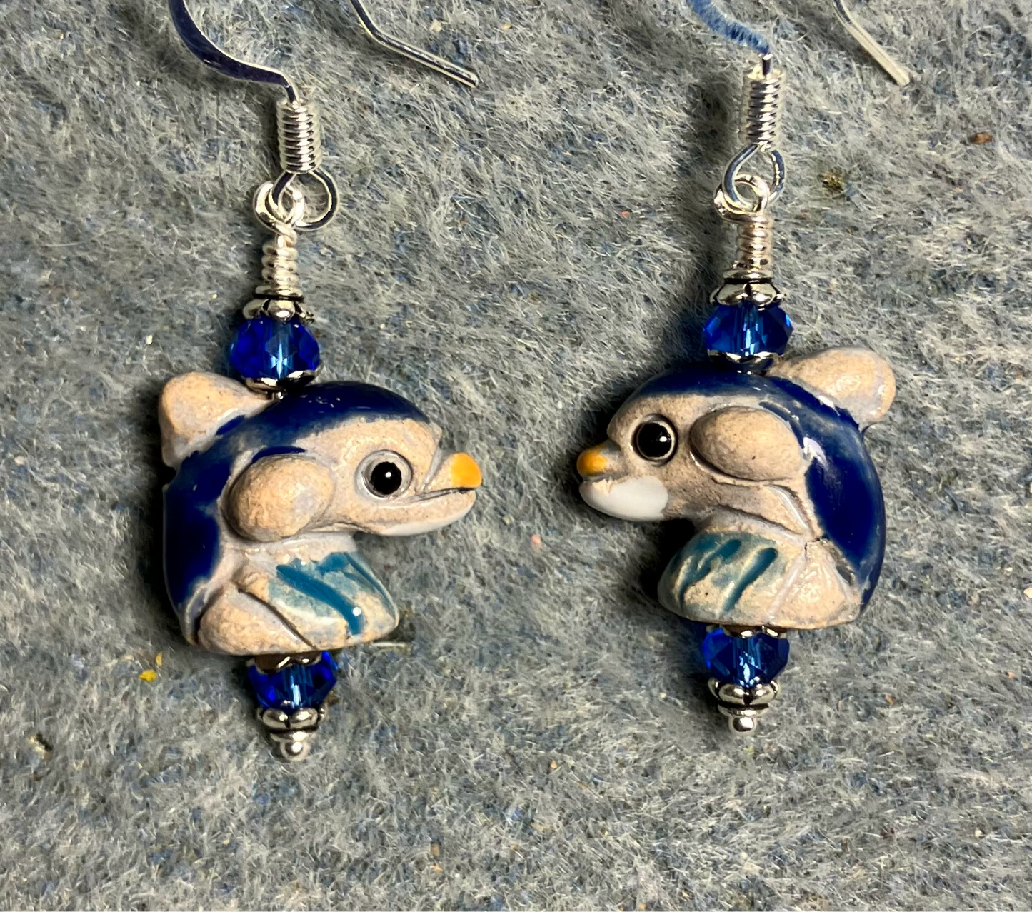Small dark blue and beige ceramic dolphin bead earrings adorned with dark blue Chinese crystal beads.