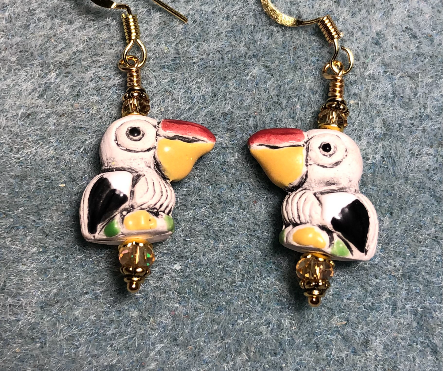 Small tan, amber, and red ceramic pelican bead earrings adorned with amber Chinese crystal beads.
