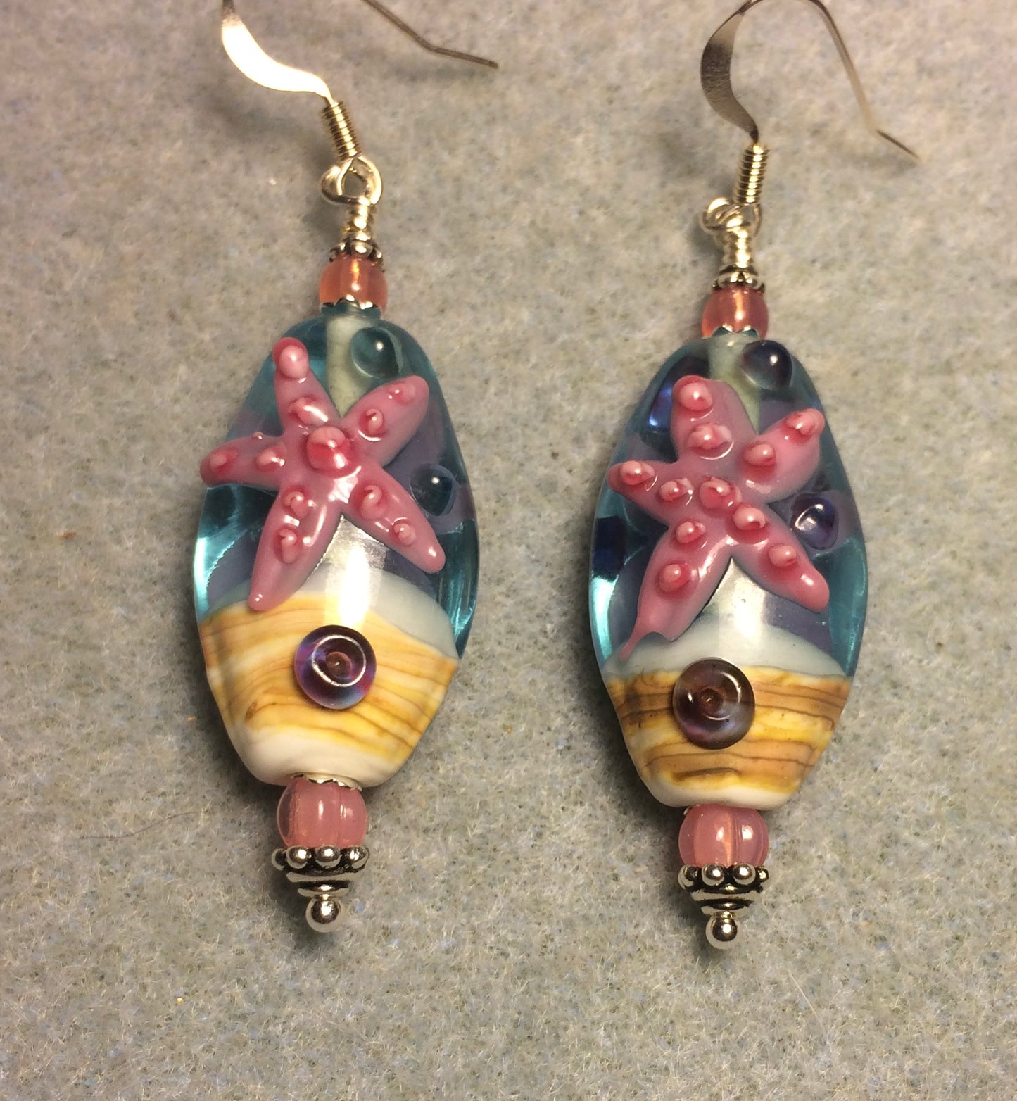 Turquoise, white, and pink lamp work starfish bead earrings adorned with pink Czech glass beads.