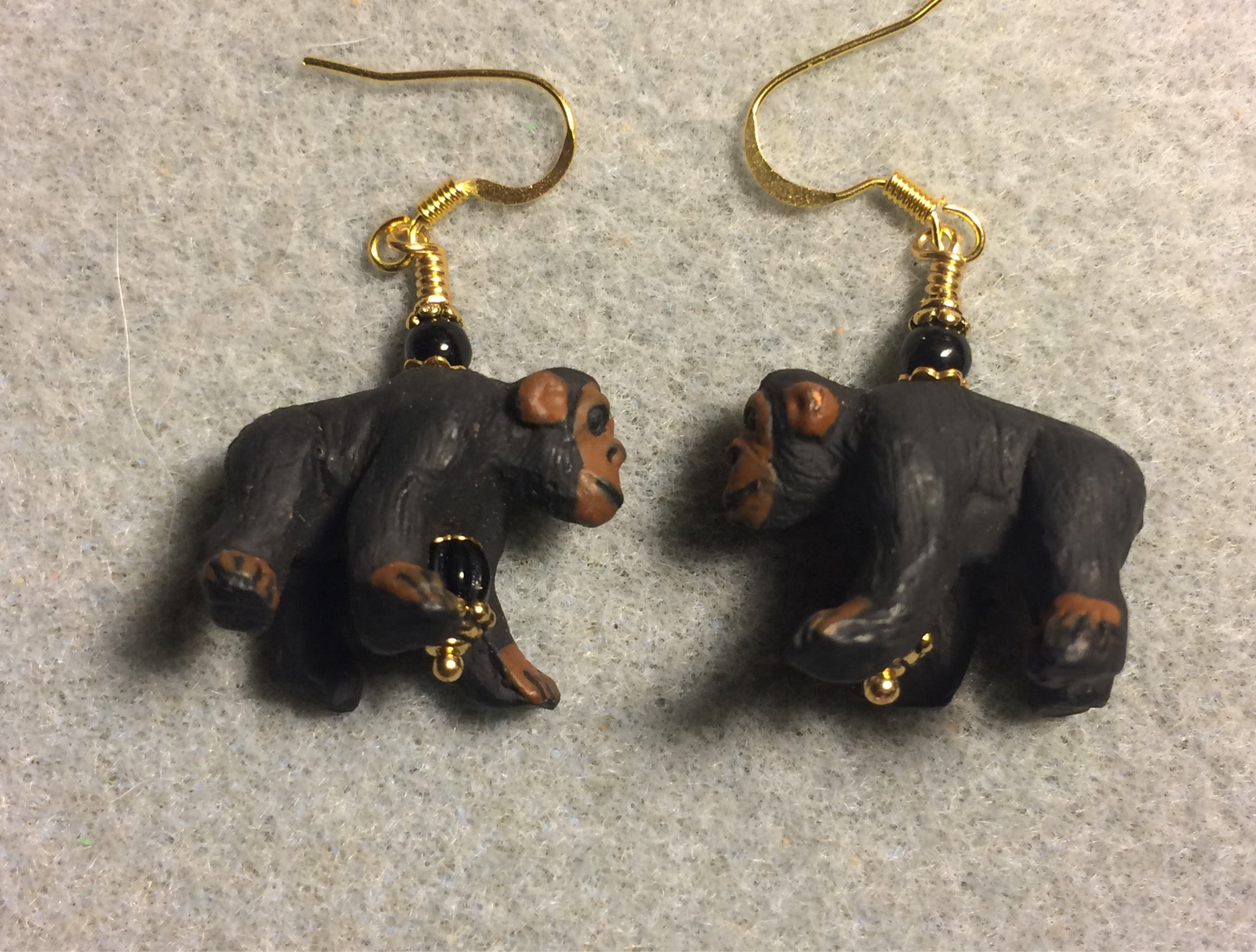 Large black and brown ceramic chimpanzee bead earrings adorned with black Czech glass beads.