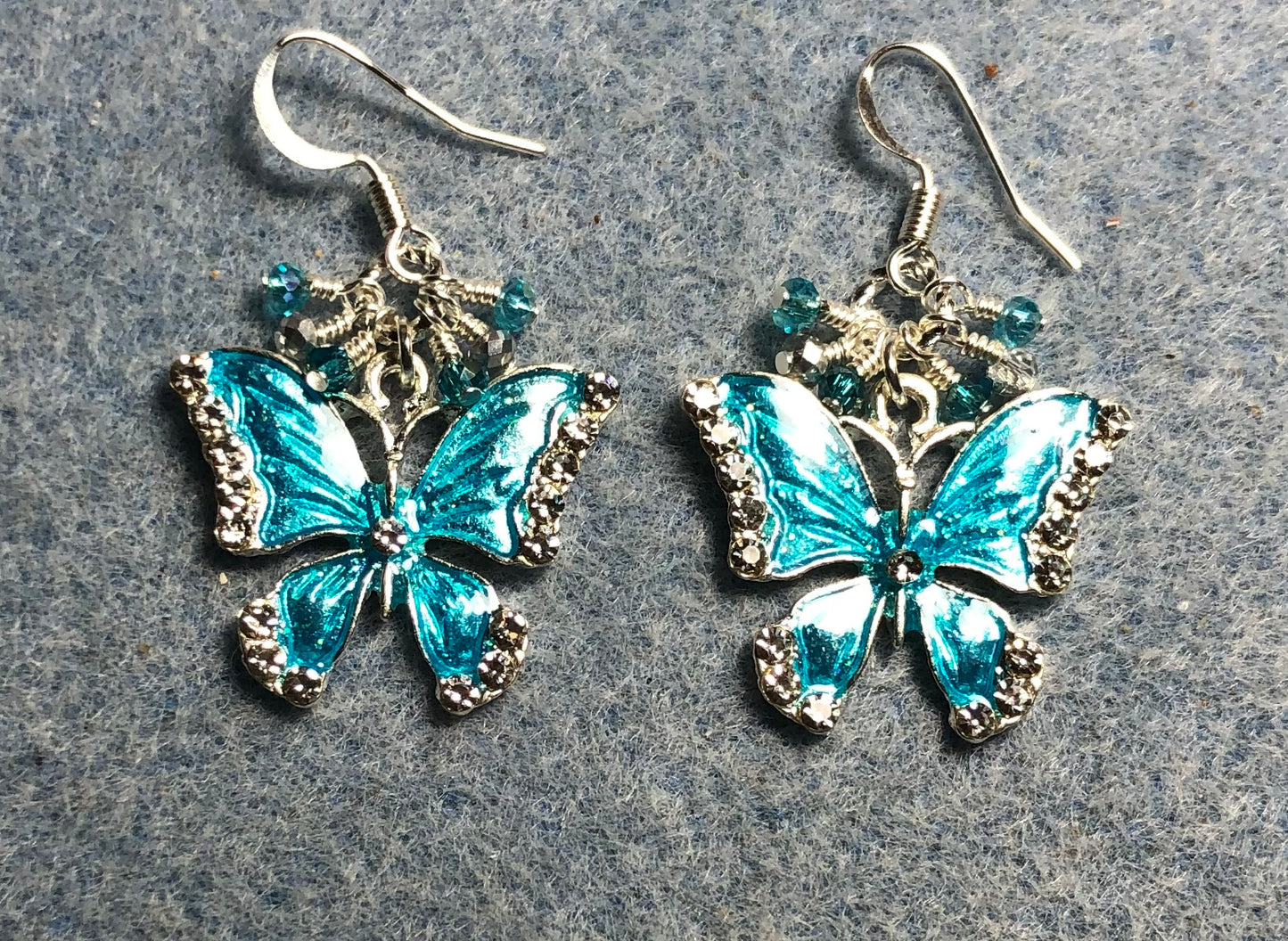 Silver and turquoise enamel and rhinestone butterfly charm earrings adorned with tiny dangling turquoise and silver Chinese crystal beads.