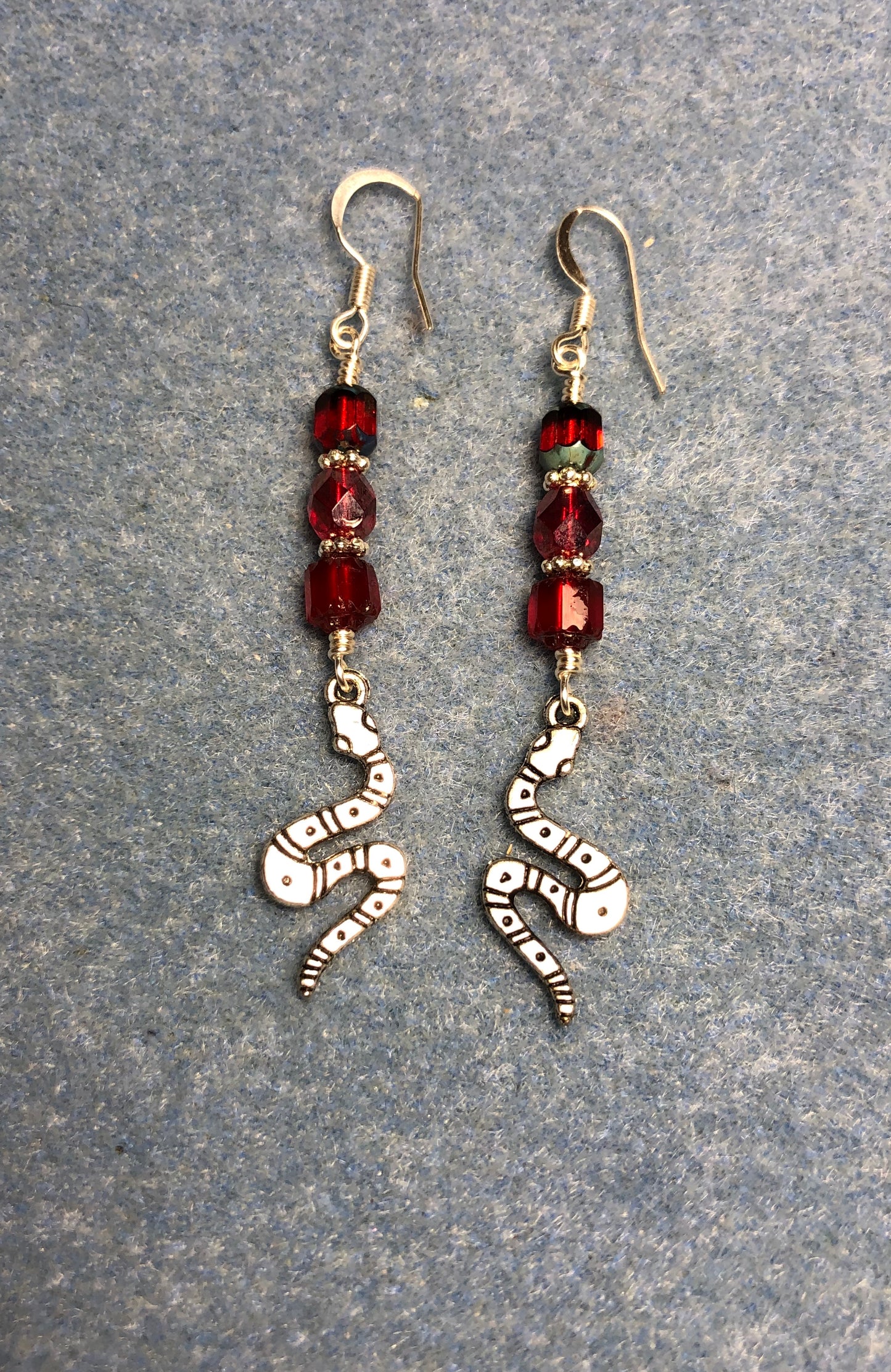 Silver coiled snake charm earrings adorned with red Czech glass beads