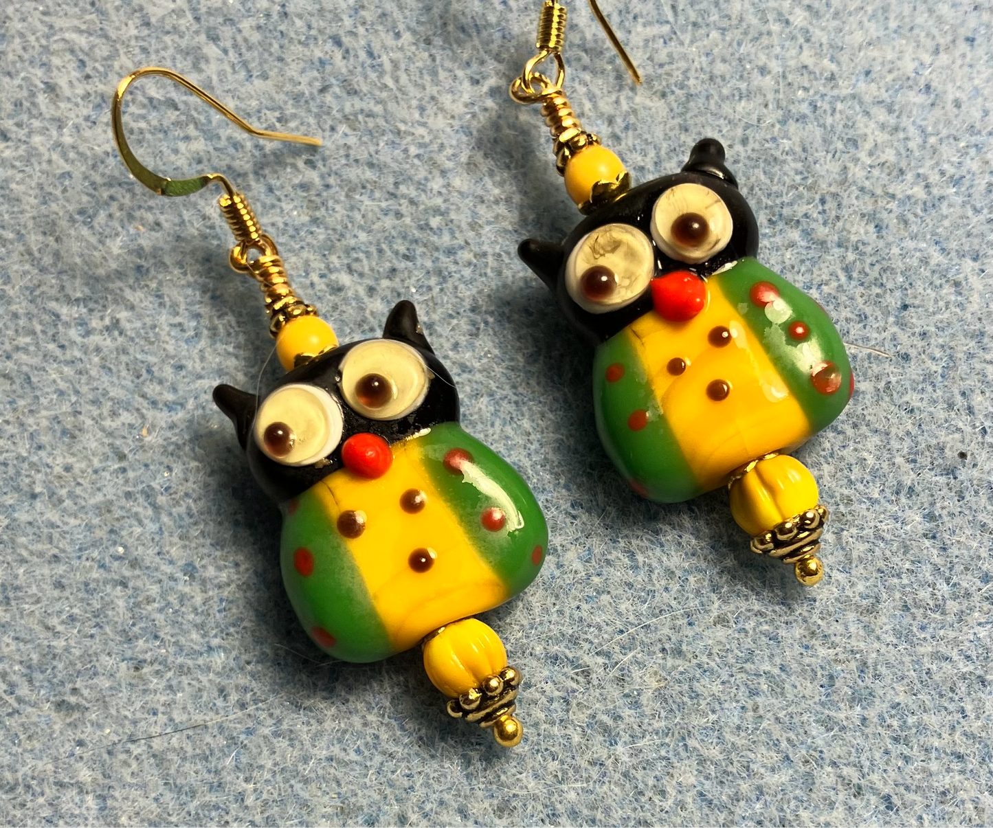 Green and golden yellow lamp work owl bead earrings adorned with golden yellow Czech glass beads.