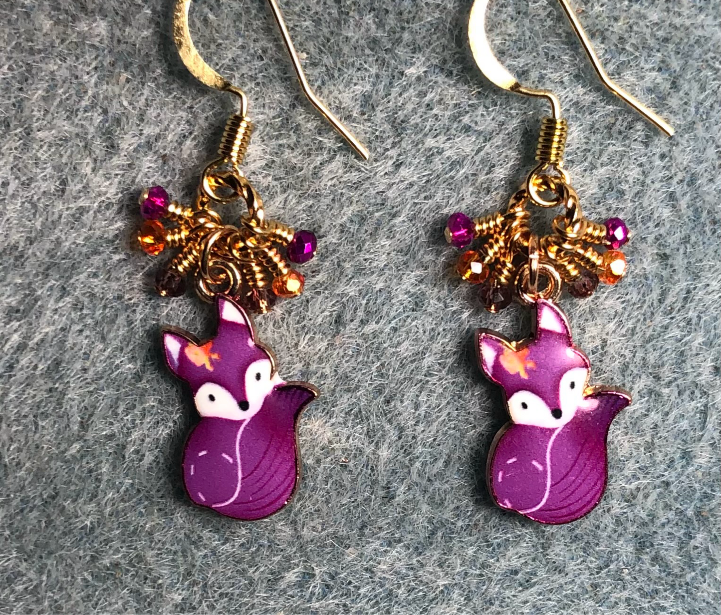 Small purple and orange enamel fox charm earrings adorned with tiny dangling purple and orange Chinese crystal beads.