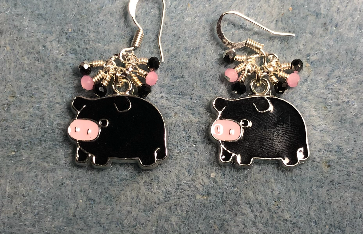 Black, pink, and silver enamel pig charm earrings adorned with tiny dangling black and pink Chinese crystal beads.