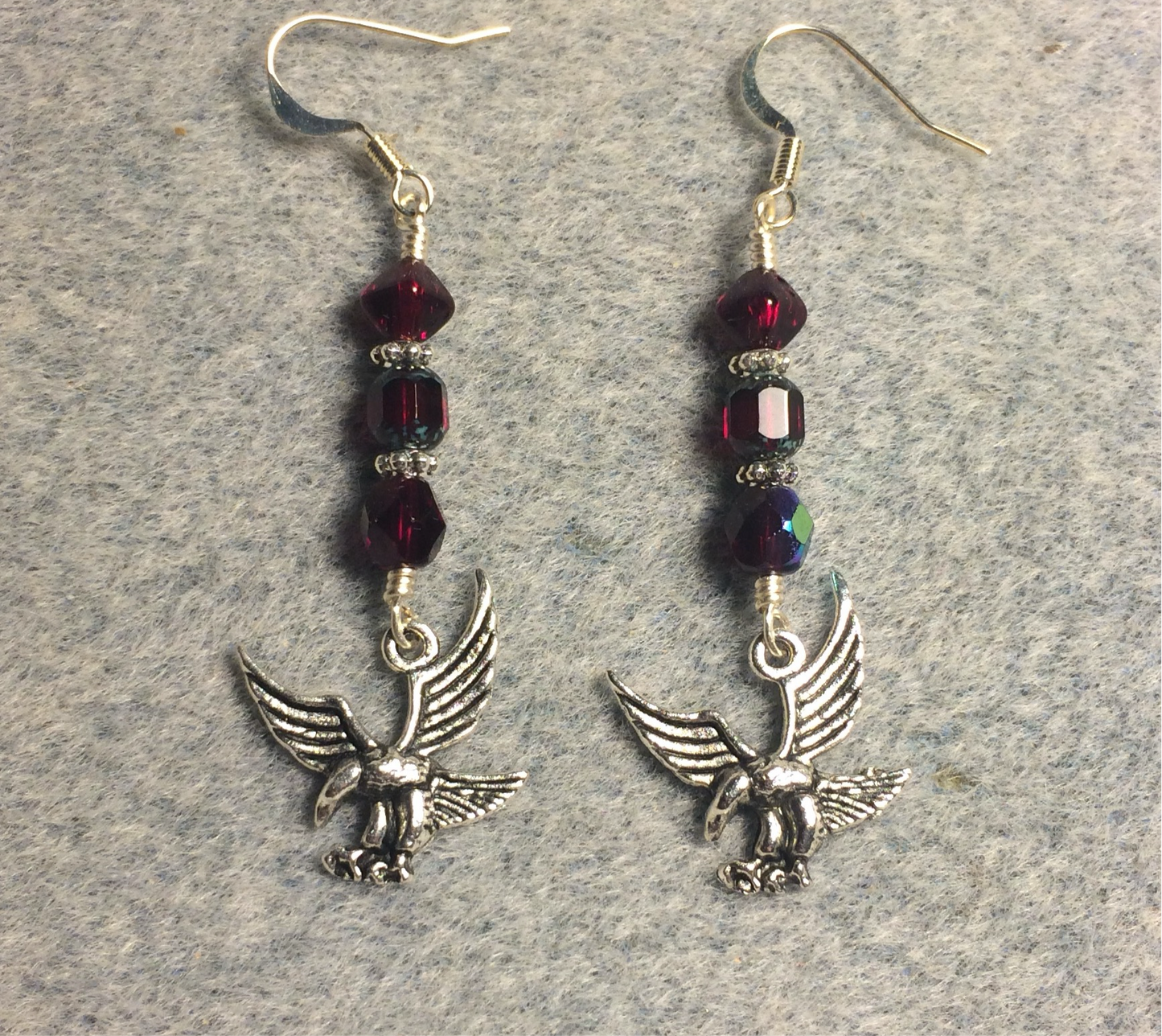 Silver flying hawk charm earrings adorned with ruby red Czech glass beads