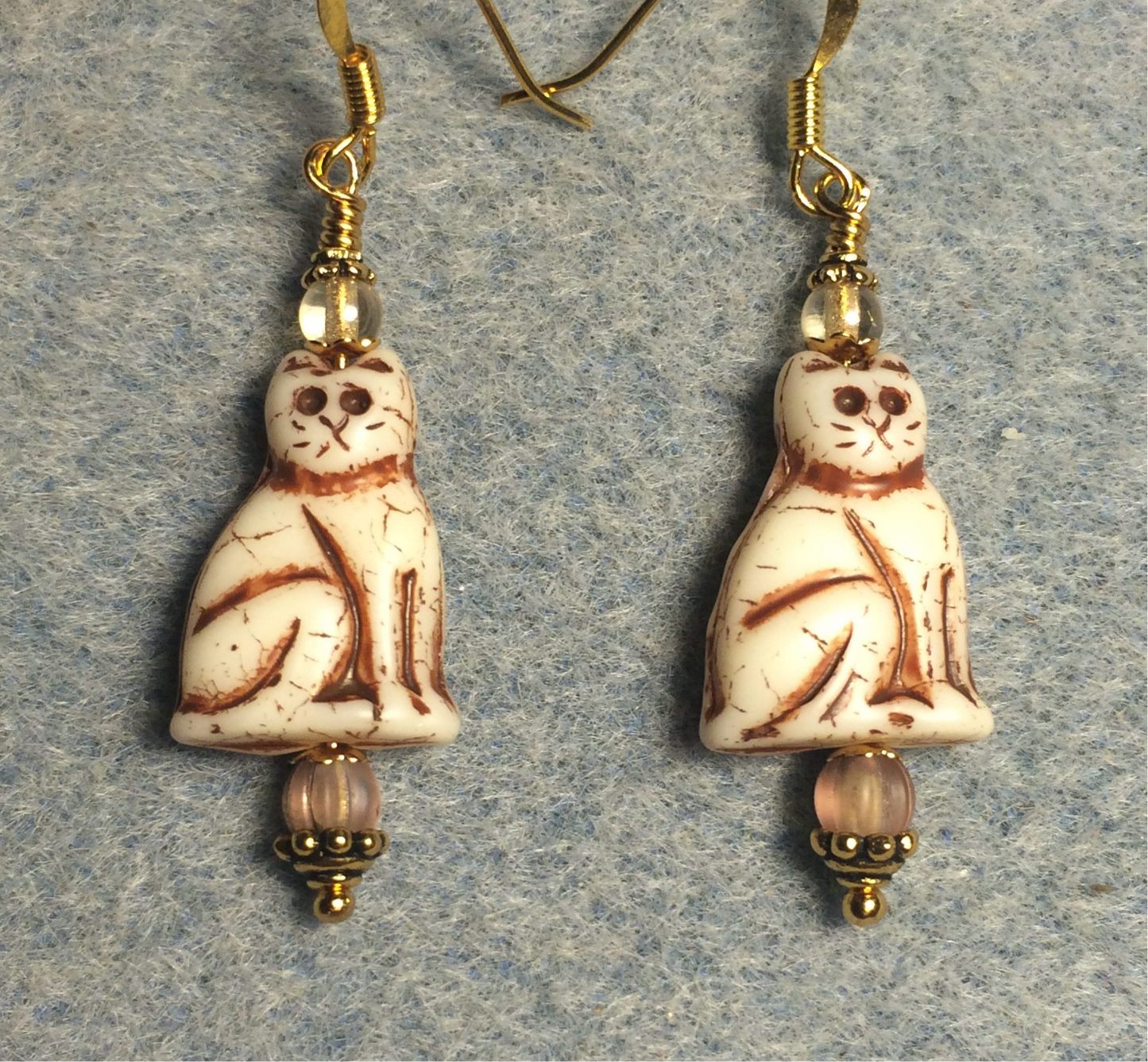 Opaque beige (with brown inlay) Czech glass cat bead earrings adorned with beige Czech glass beads.