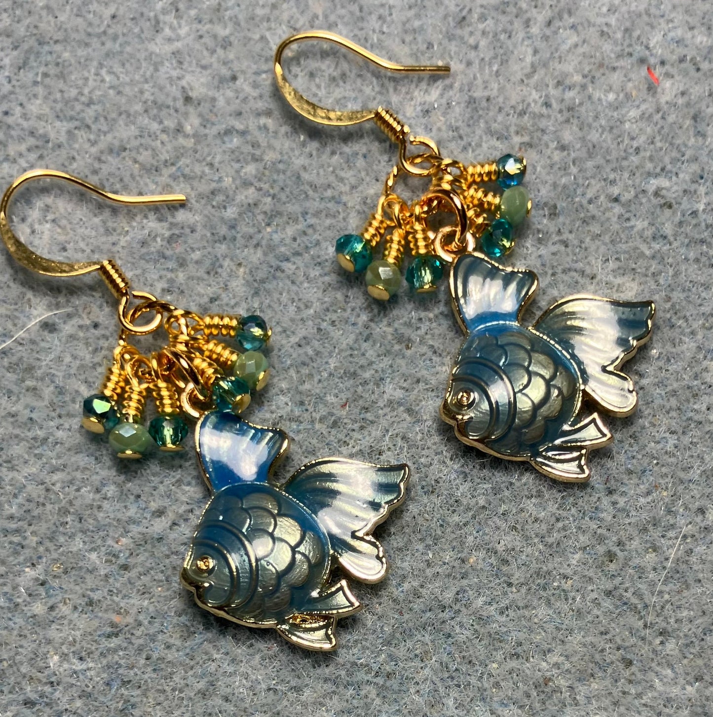 Metallic turquoise enamel angelfish charm earrings adorned with tiny dangling turquoise Chinese crystal beads.