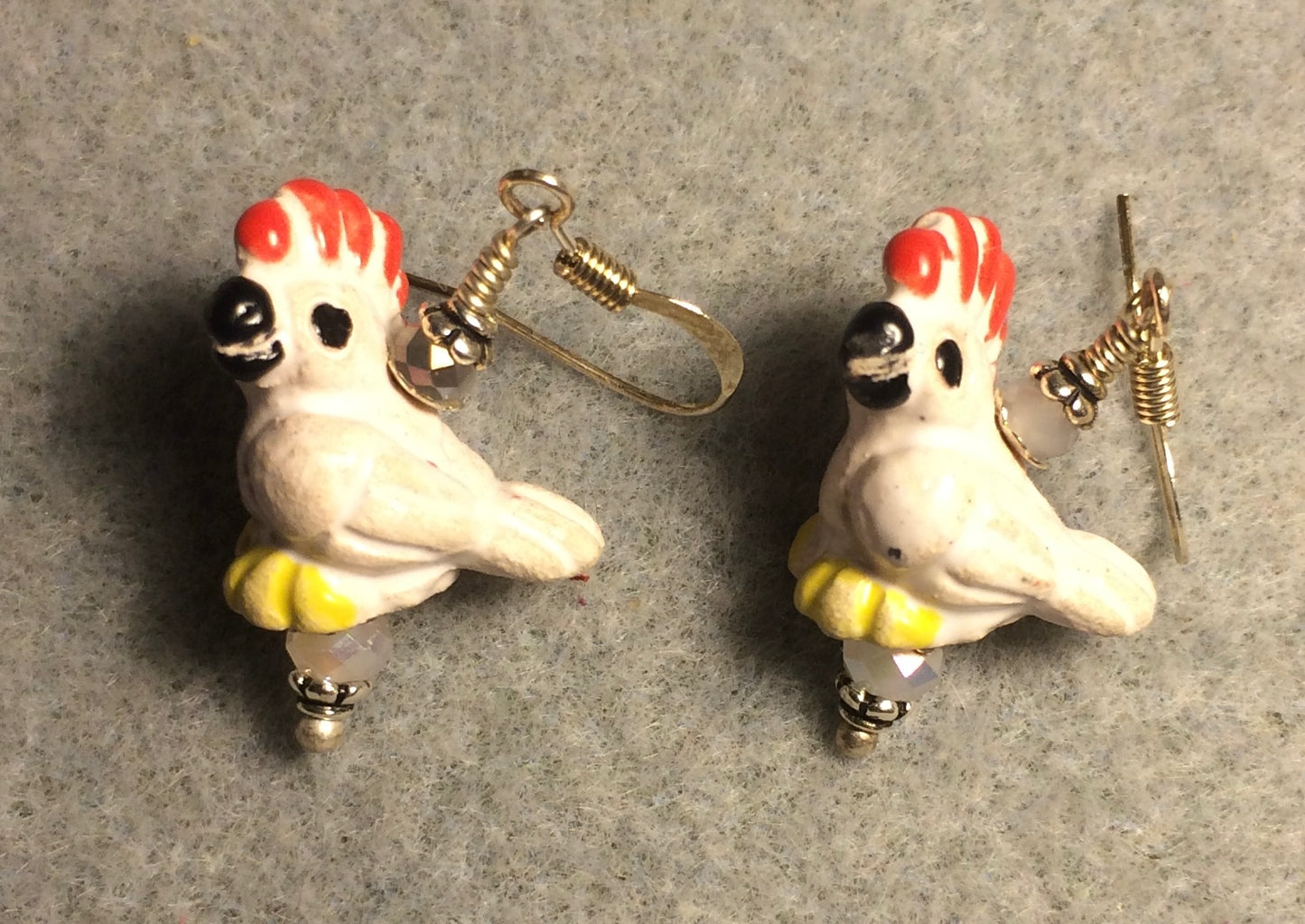 Small white, yellow, and red ceramic cockatoo bead earrings adorned with white Chinese crystal beads.