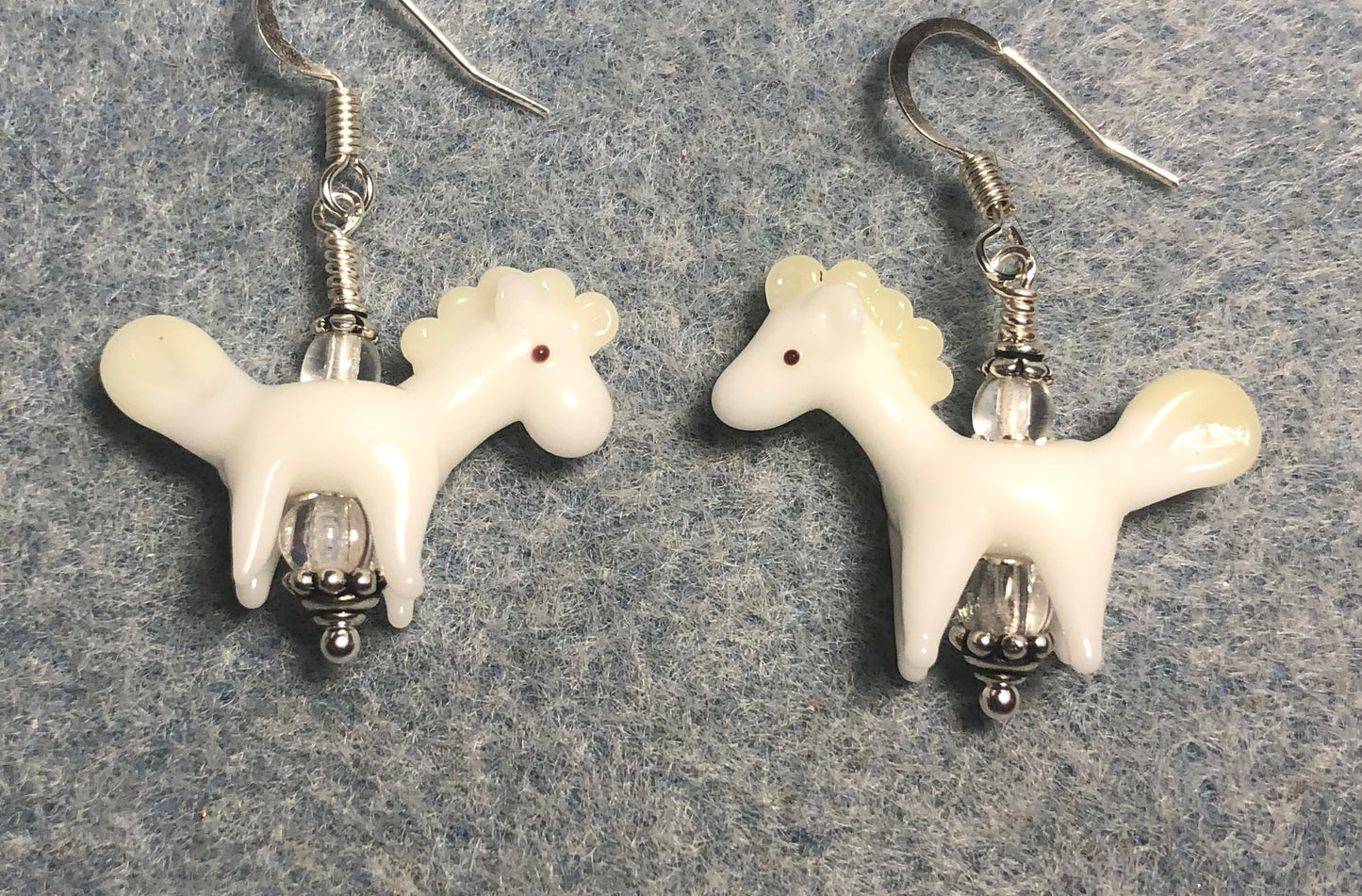 White lamp work horse bead earrings adorned with clear Czech glass beads.