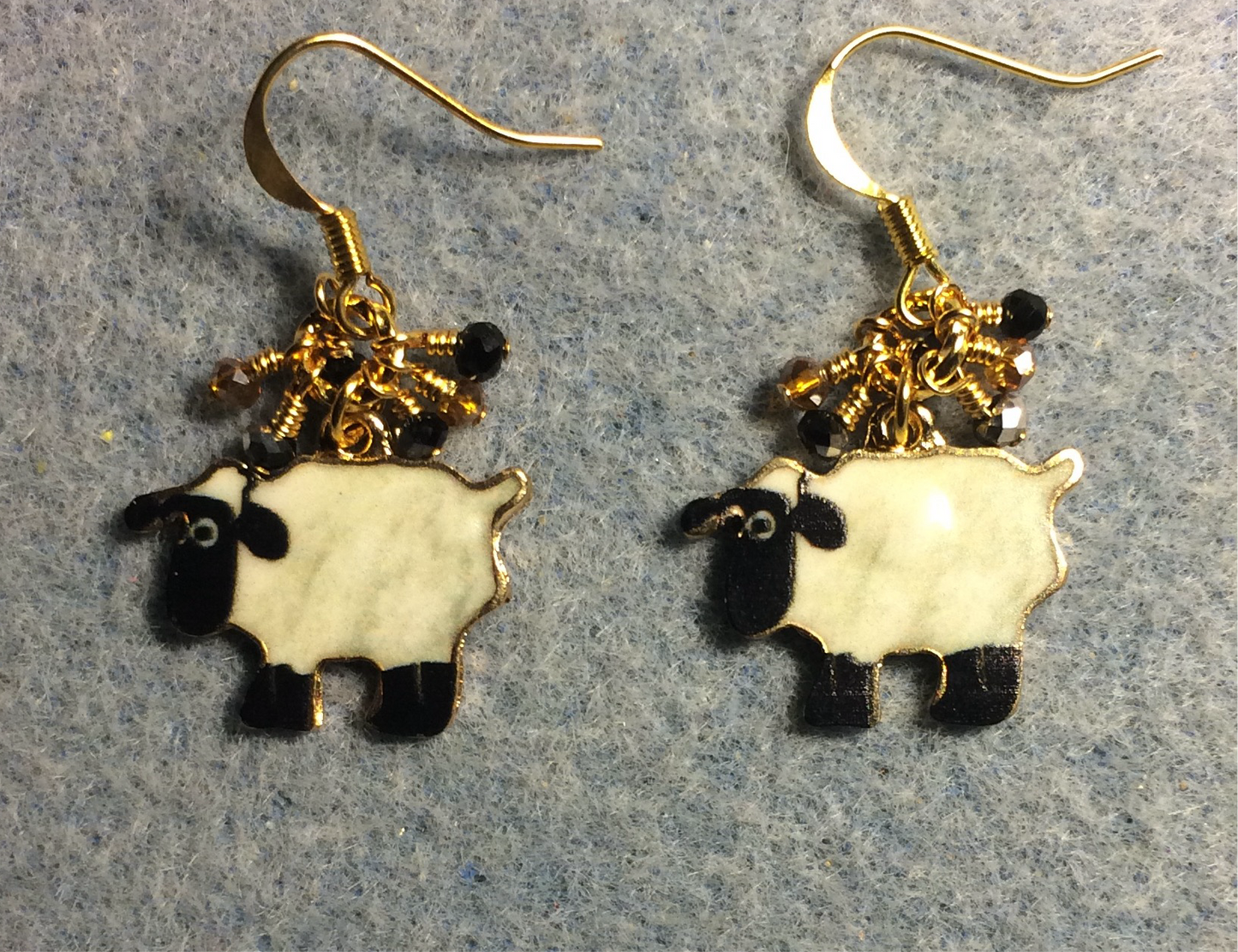 Black and white enamel sheep charm earrings adorned with tiny dangling black, white, and amber Chinese crystal beads.