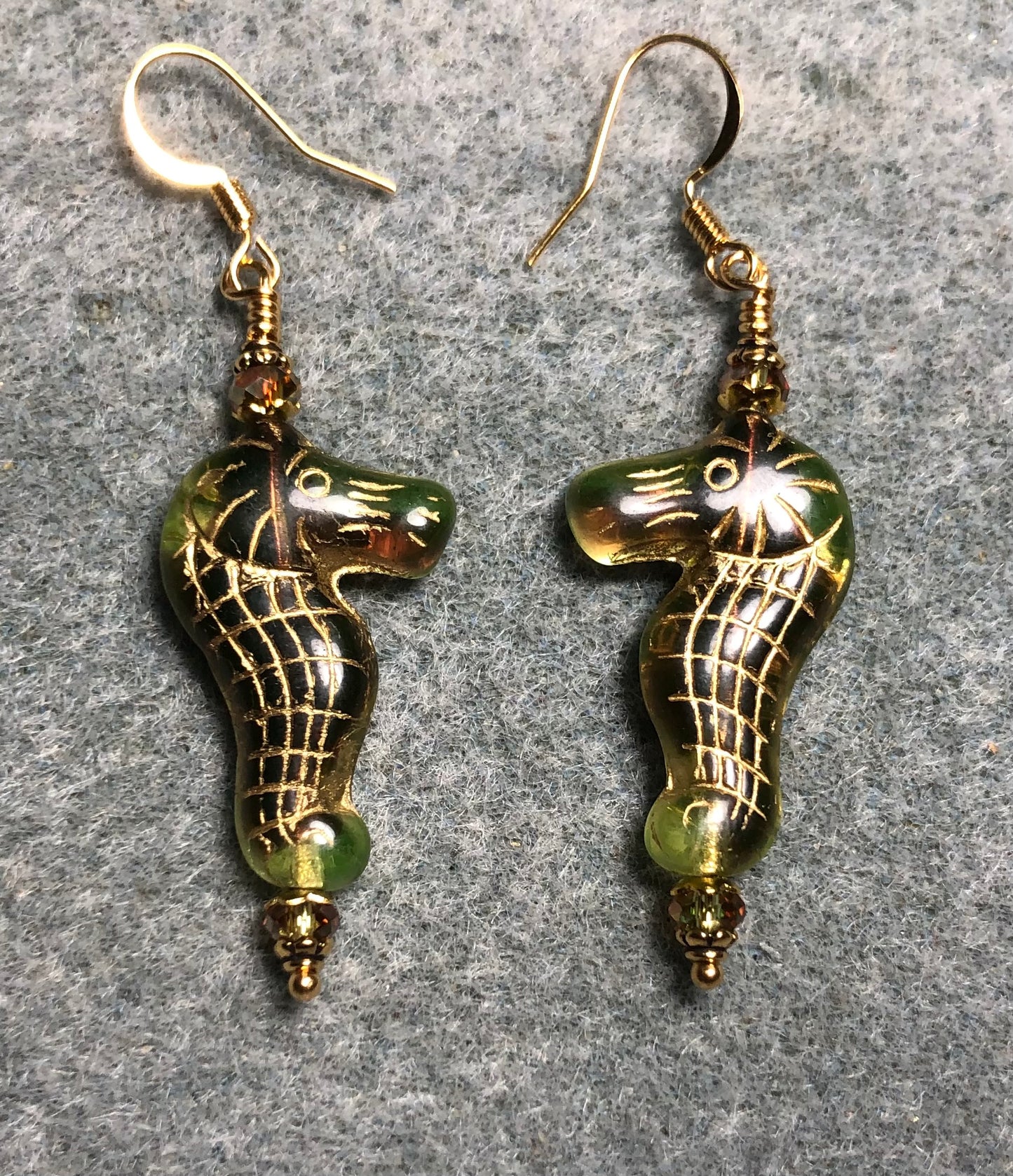 Green (with gold inlay) Czech glass seahorse bead earrings adorned with sparkly green Chinese crystal beads.