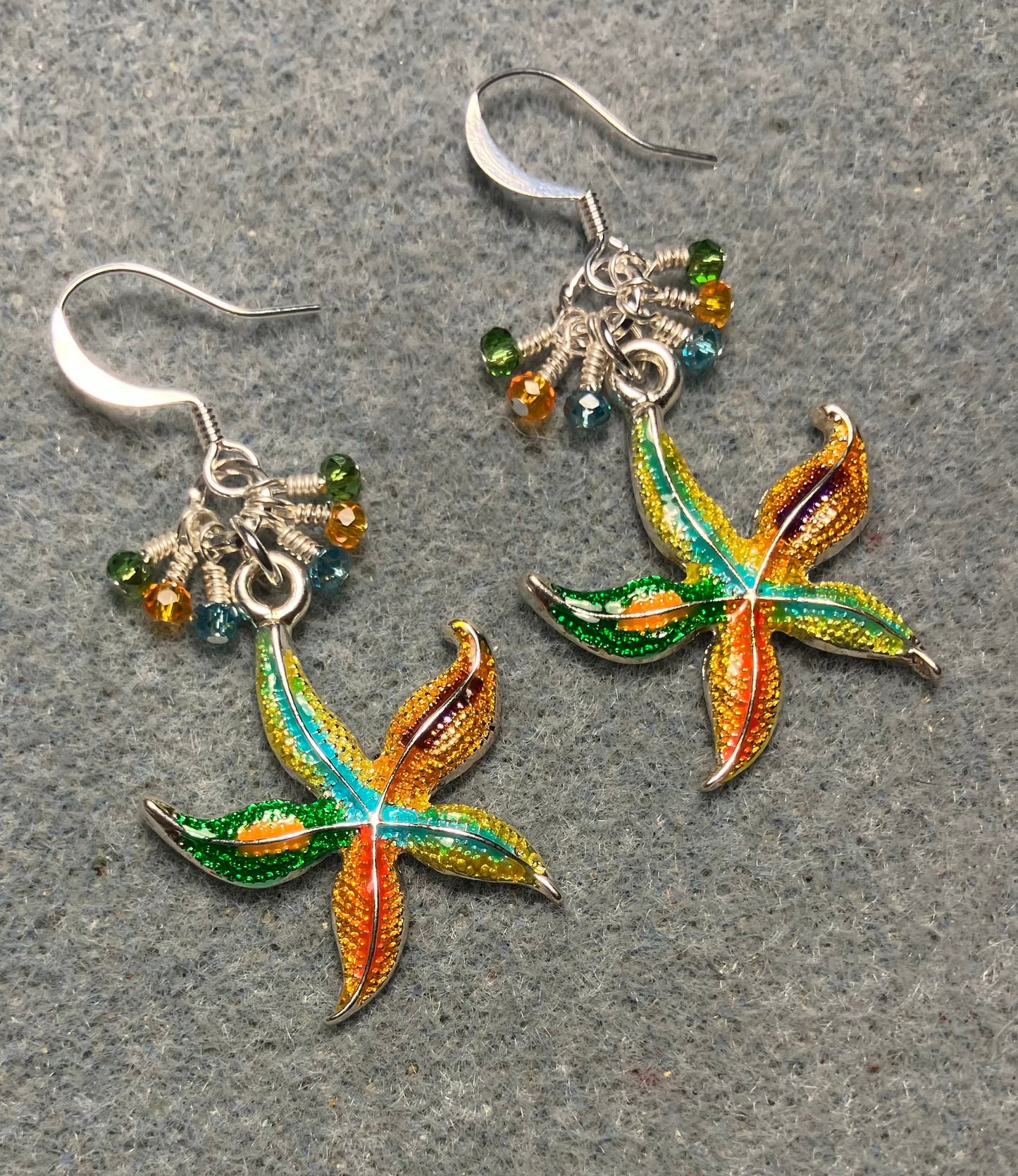 Silver, orange, green, and turquoise enamel starfish charm earrings adorned with tiny dangling turquoise, orange, and green Chinese crystal beads.