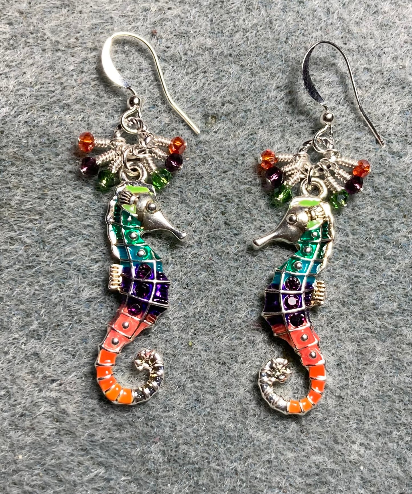 Orange, purple, and olive green enamel seahorse charm earrings adorned with tiny dangling orange, purple, and olive green Chinese crystal beads.
