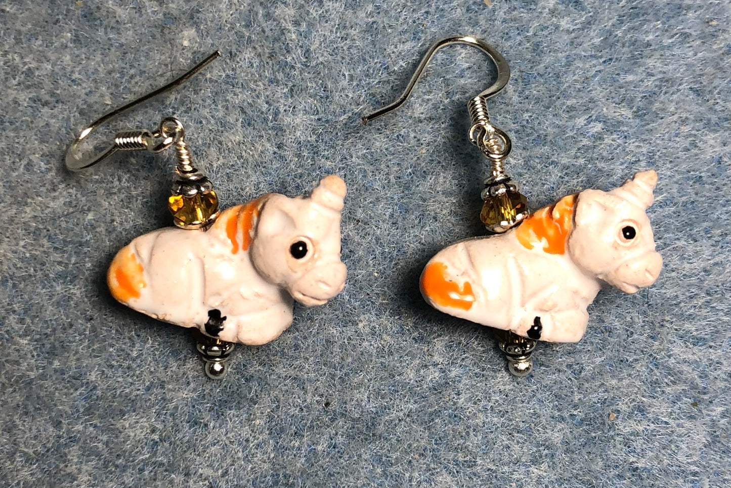 Small white and amber ceramic unicorn bead earrings adorned with amber Chinese crystal beads.