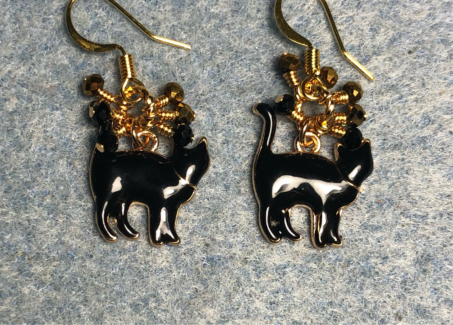 Small black enamel cat charm earrings adorned with tiny dangling black and gold Chinese crystal beads.