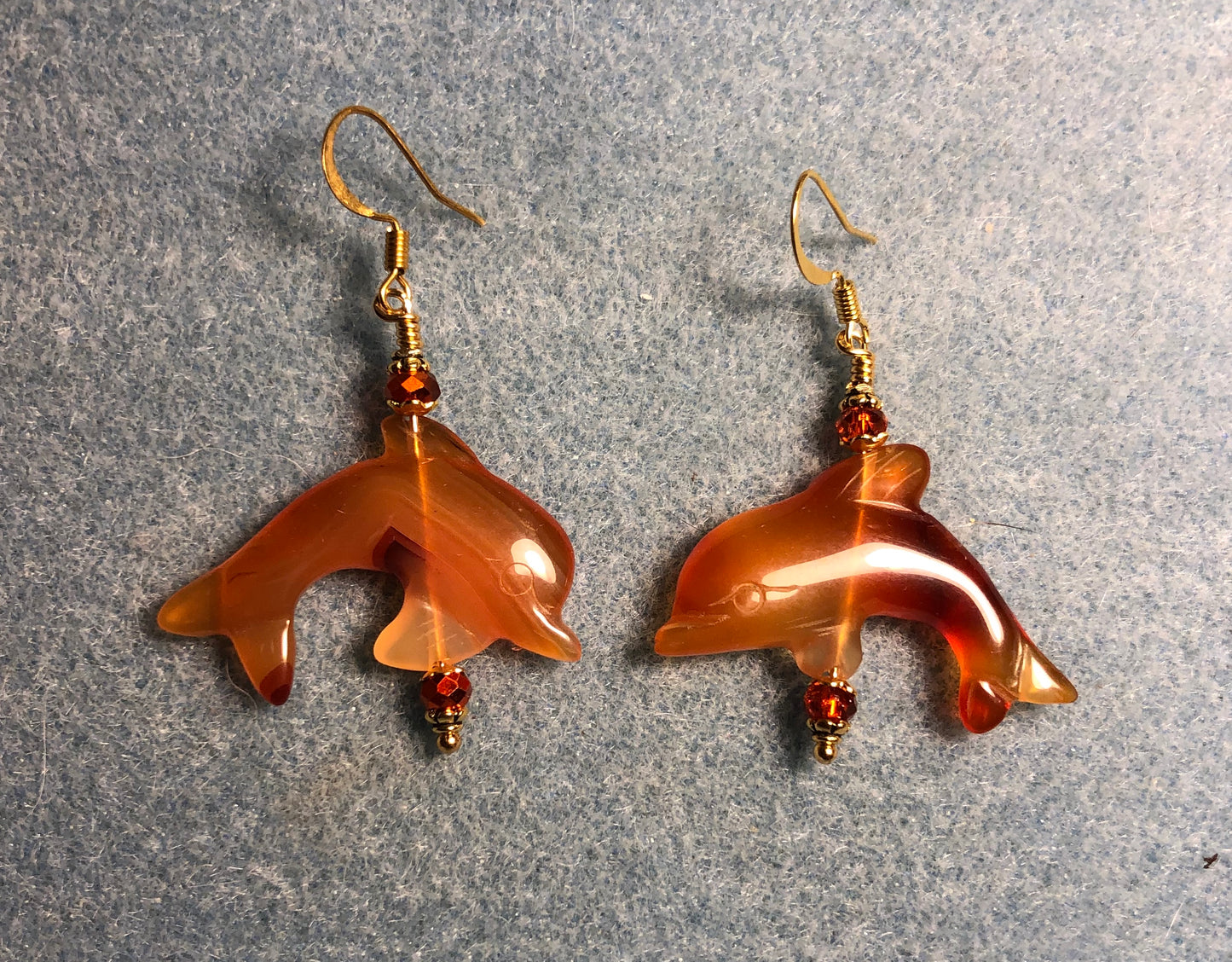 Carnelian gemstone dolphin bead earrings adorned with orange Chinese crystal beads.