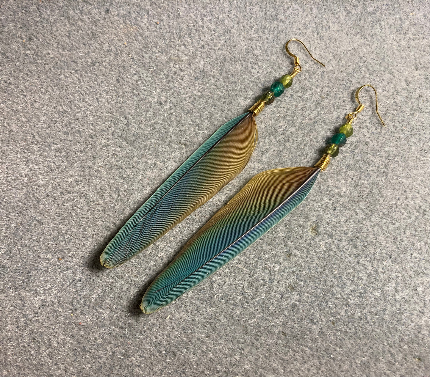 Turquoise and olive green mini macaw feather earrings adorned with turquoise and olive green Czech glass beads.