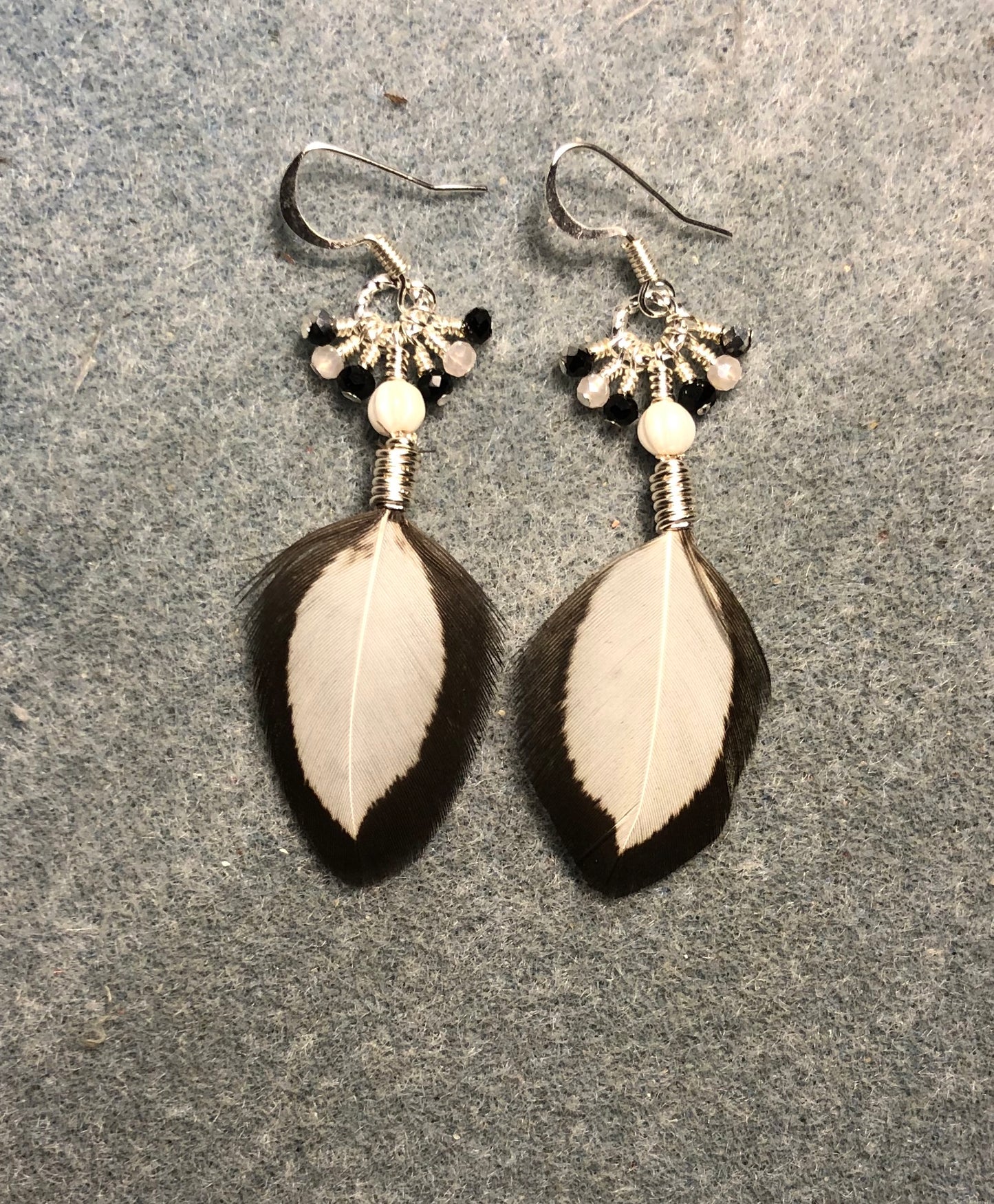 Small white and black chicken feather earrings adorned with white Czech glass beads and tiny dangling white and black Chinese crystal beads.