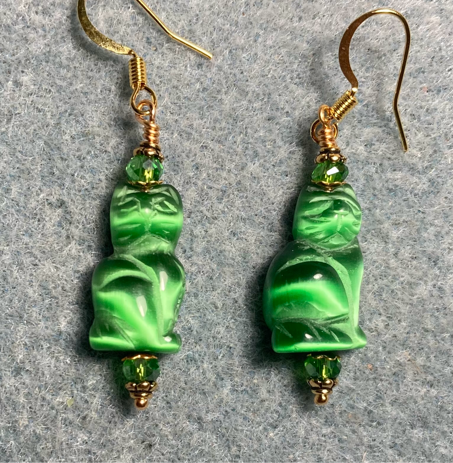 Emerald green fiber optic (cat’s eye) cat bead earrings adorned with emerald green Chinese crystal beads.