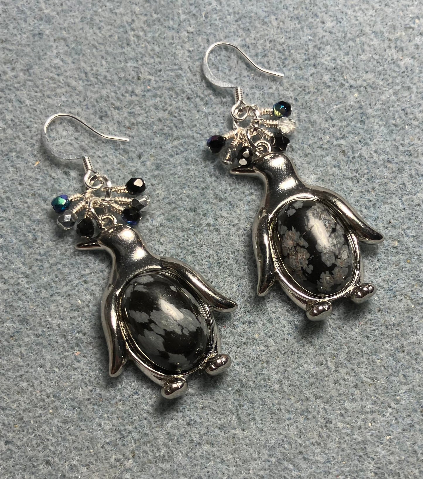 Large silver and snow jasper gemstone penguin charm earrings adorned with small dangling black and silver Czech glass beads.