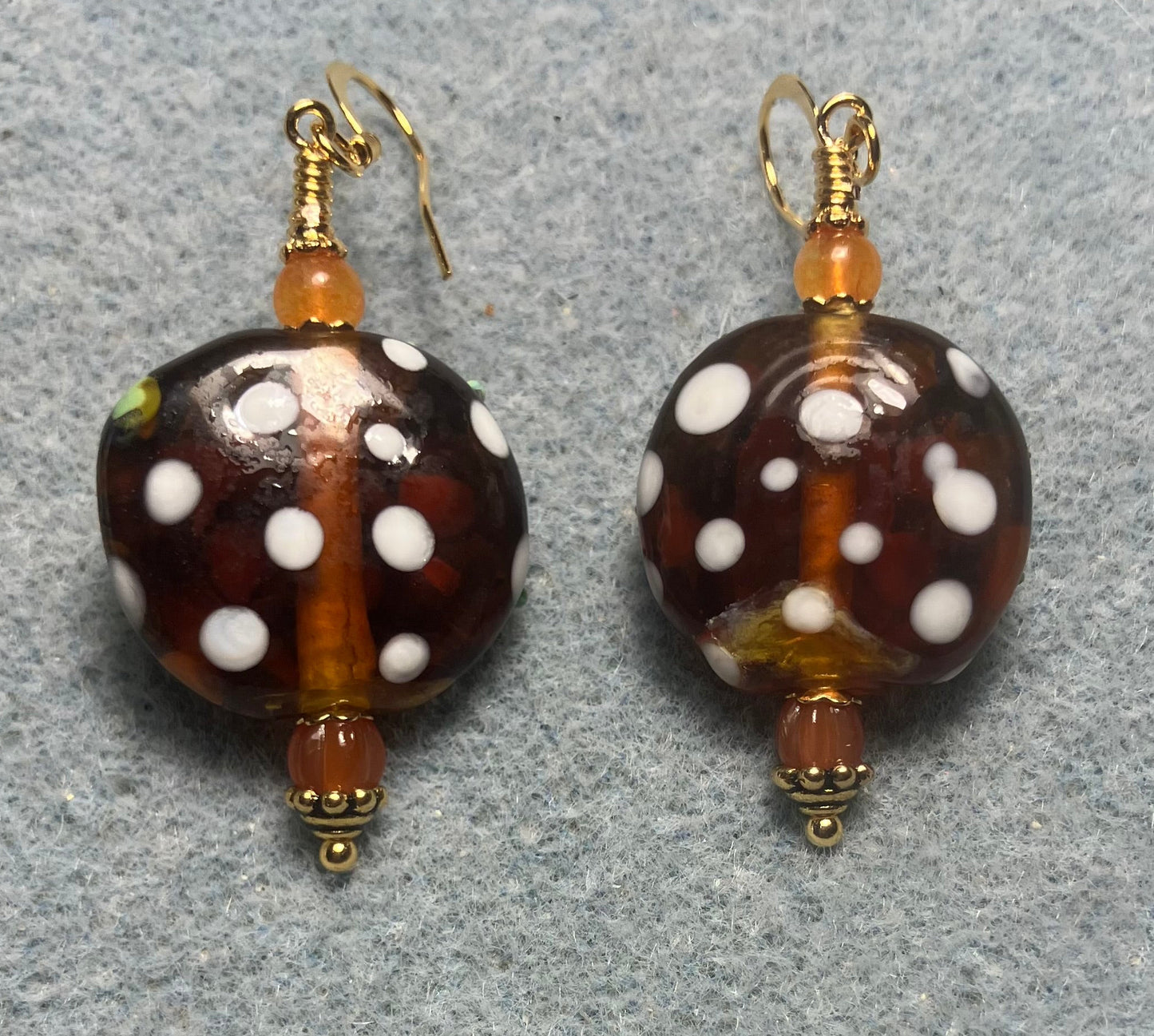 Orange and green lamp work frog bead earrings adorned with orange Czech glass beads.