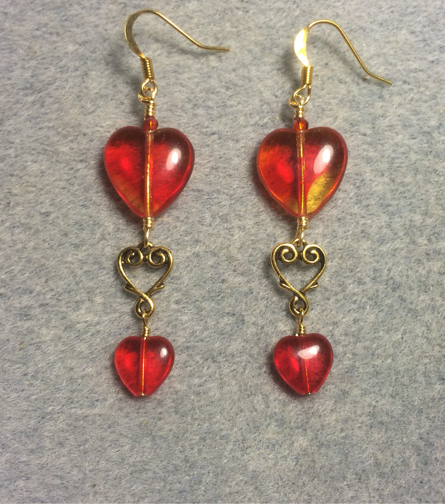 Large and small matching bright red Czech glass heart bead earrings joined by gold Tierracast heart connectors.