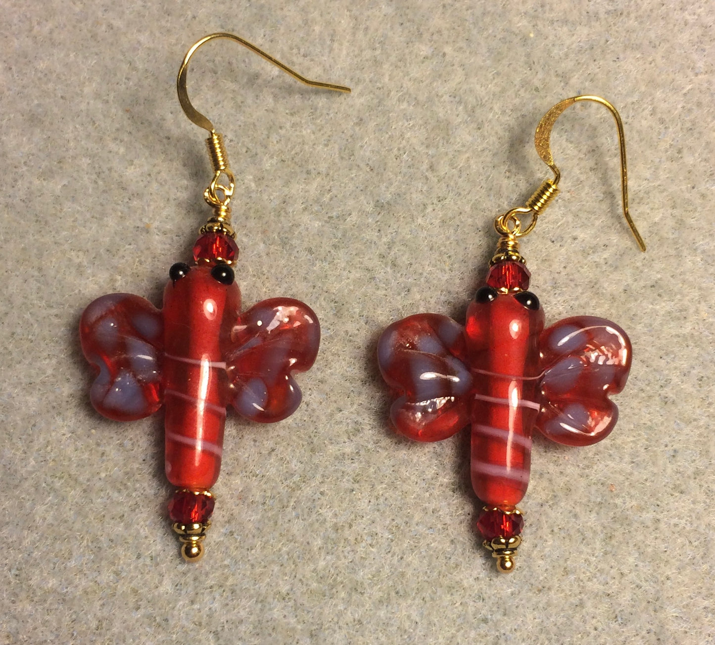Red and purple lamp work dragonfly bead earrings adorned with red Chinese crystal beads.