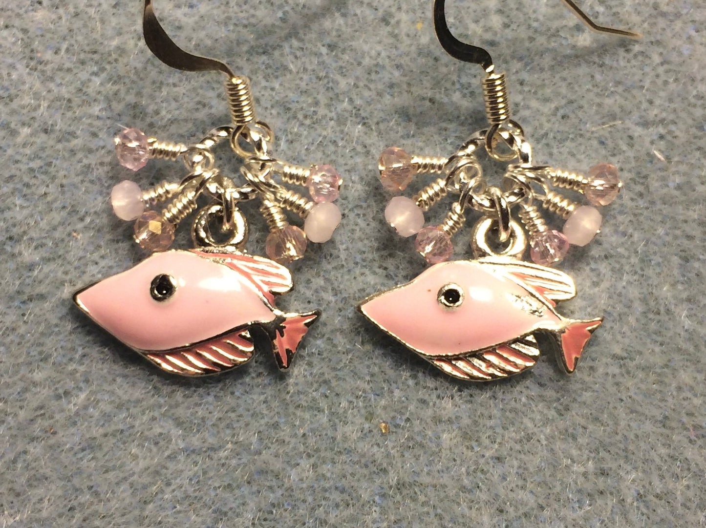 Light pink enamel fish charm earrings adorned with tiny dangling light pink Chinese crystal beads.