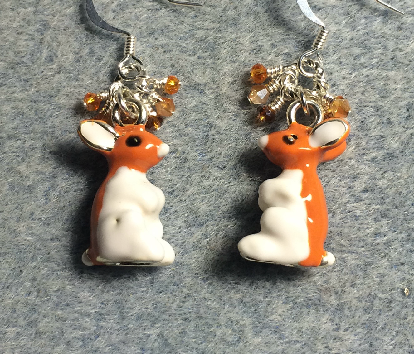 Silver, orange, and white enamel sitting rabbit charm earrings adorned with orange and silver Chinese crystal beads.