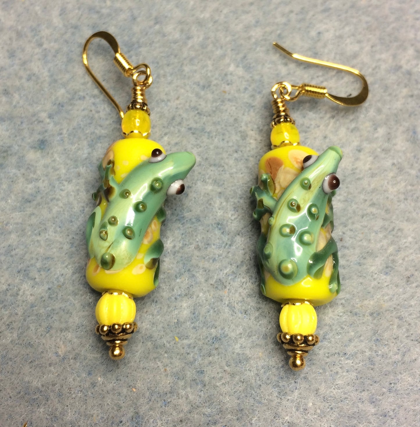 Yellow and green lamp work lizard bead earrings adorned with yellow Czech glass beads.