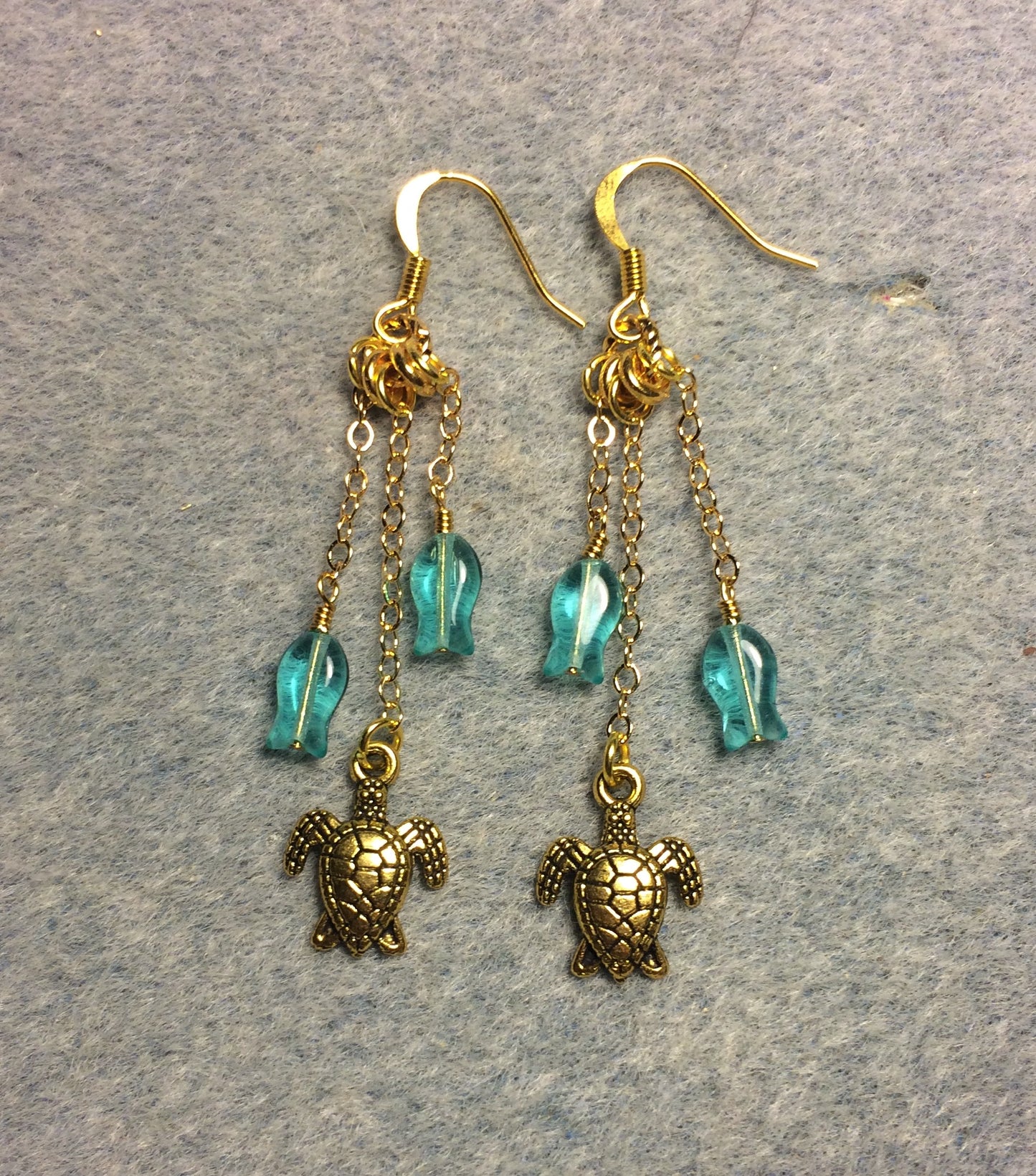 Small gold sea turtle charm earrings attached to gold chain and adorned with small teal Czech glass fish beads