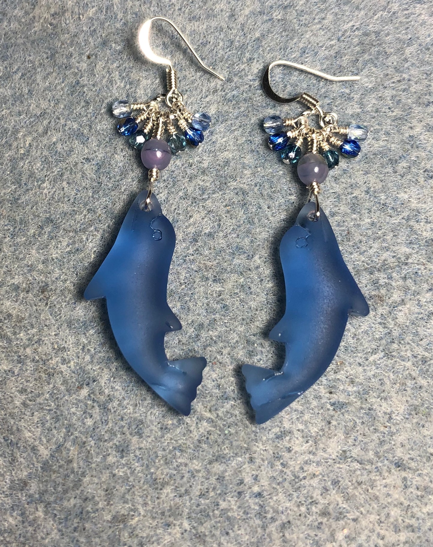 Blue sea glass dolphin pendant bead earrings adorned with blue Czech glass beads and tiny dangling blue Czech glass beads.