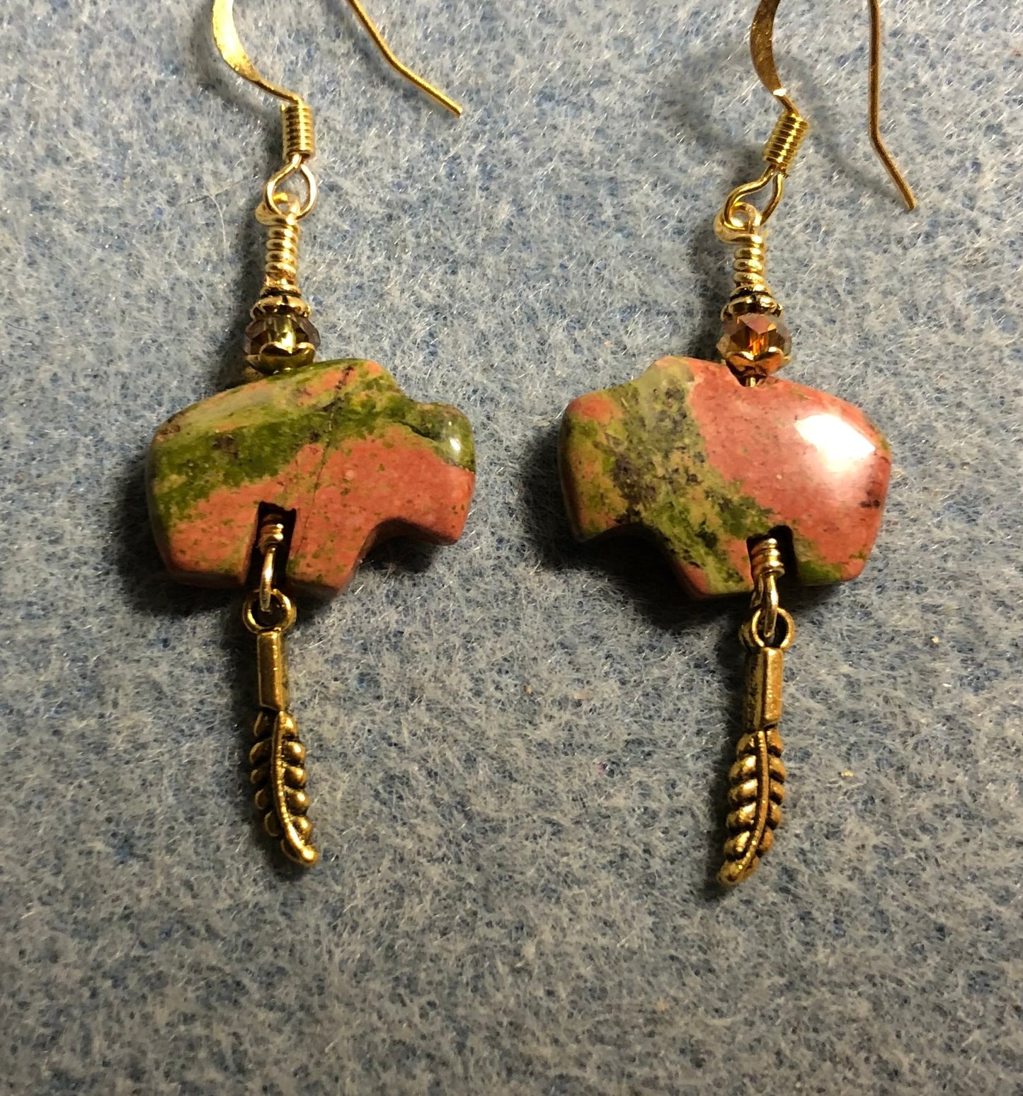 Green and orange unakite gemstone buffalo fetish bead earrings adorned with sparkly green crystal beads and tiny gold feather charms.