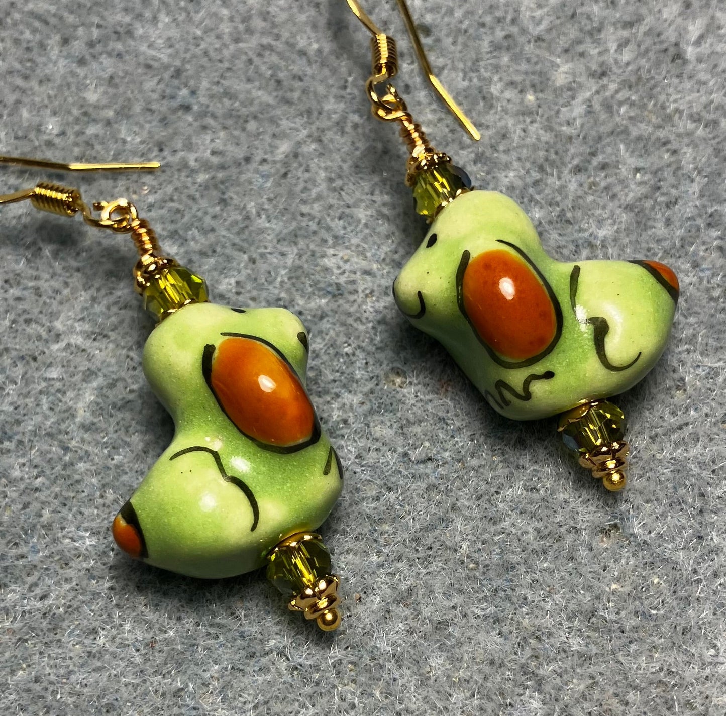 Olive green and brown ceramic puppy dog bead earrings adorned with sparkly olive green Chinese crystal beads.