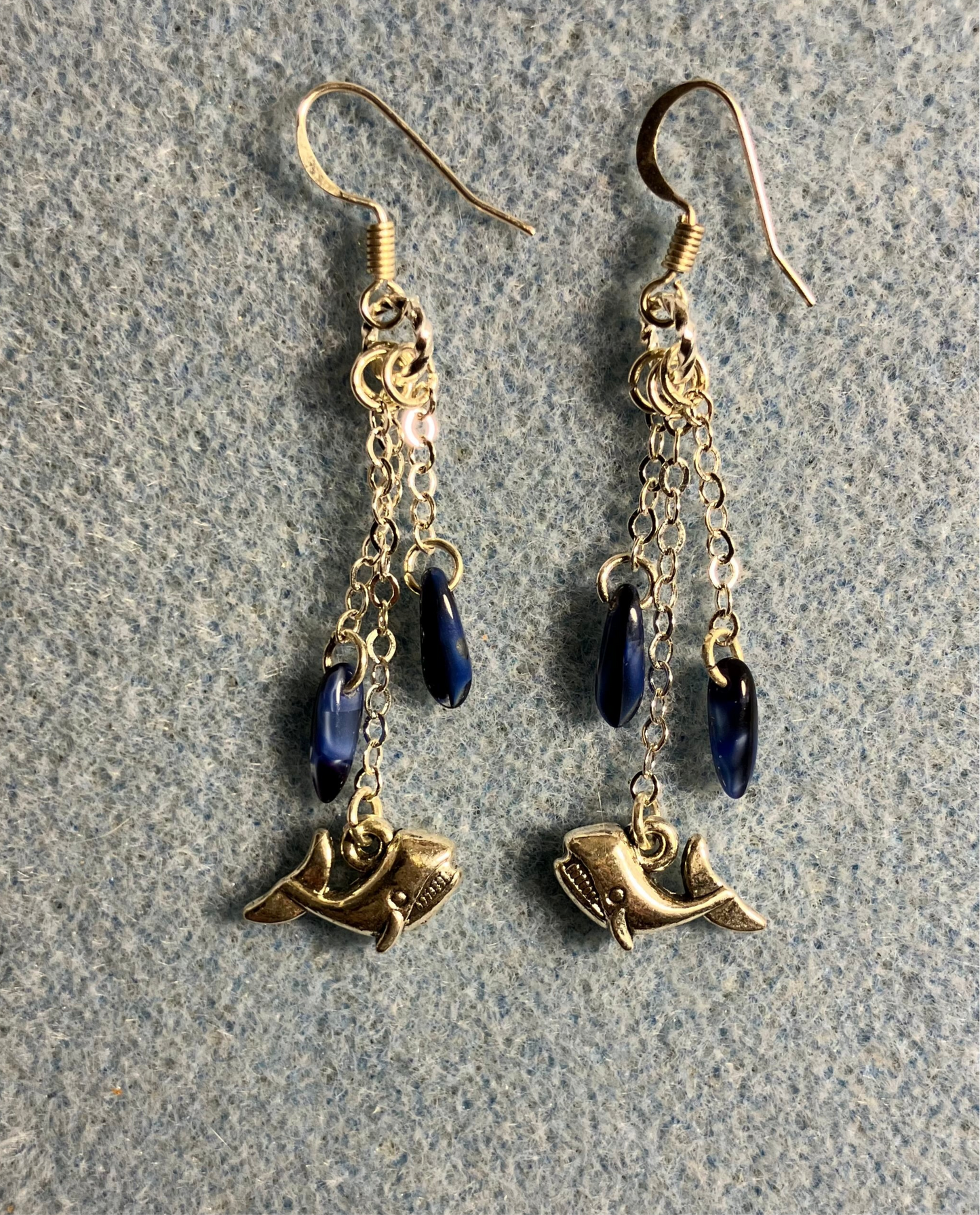 Small silver whale charm earrings attached to silver chain and adorned with small dark blue Czech glass dagger beads