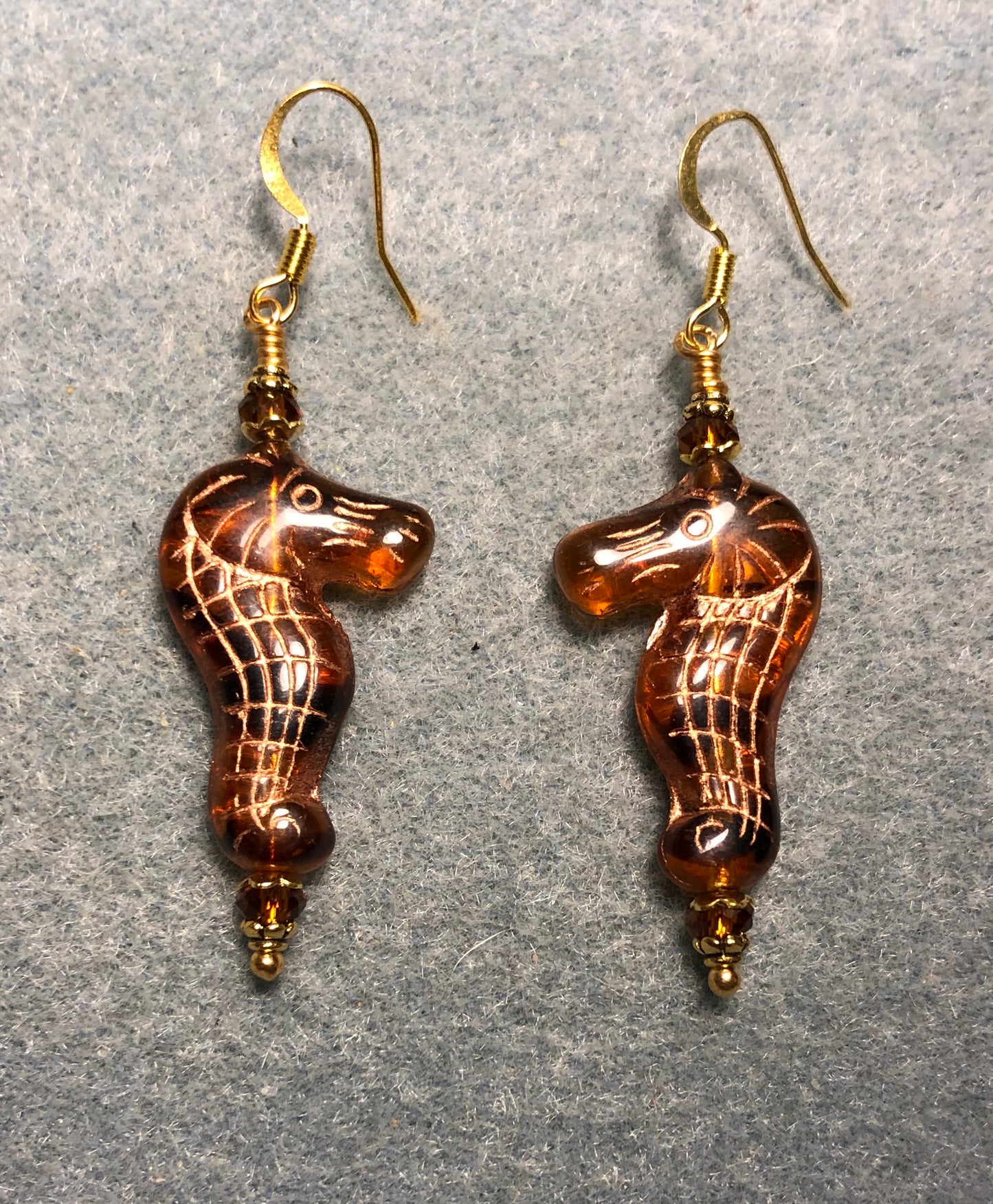 Dark amber (with gold inlay) Czech glass seahorse bead earrings adorned with dark amber Chinese crystal beads.